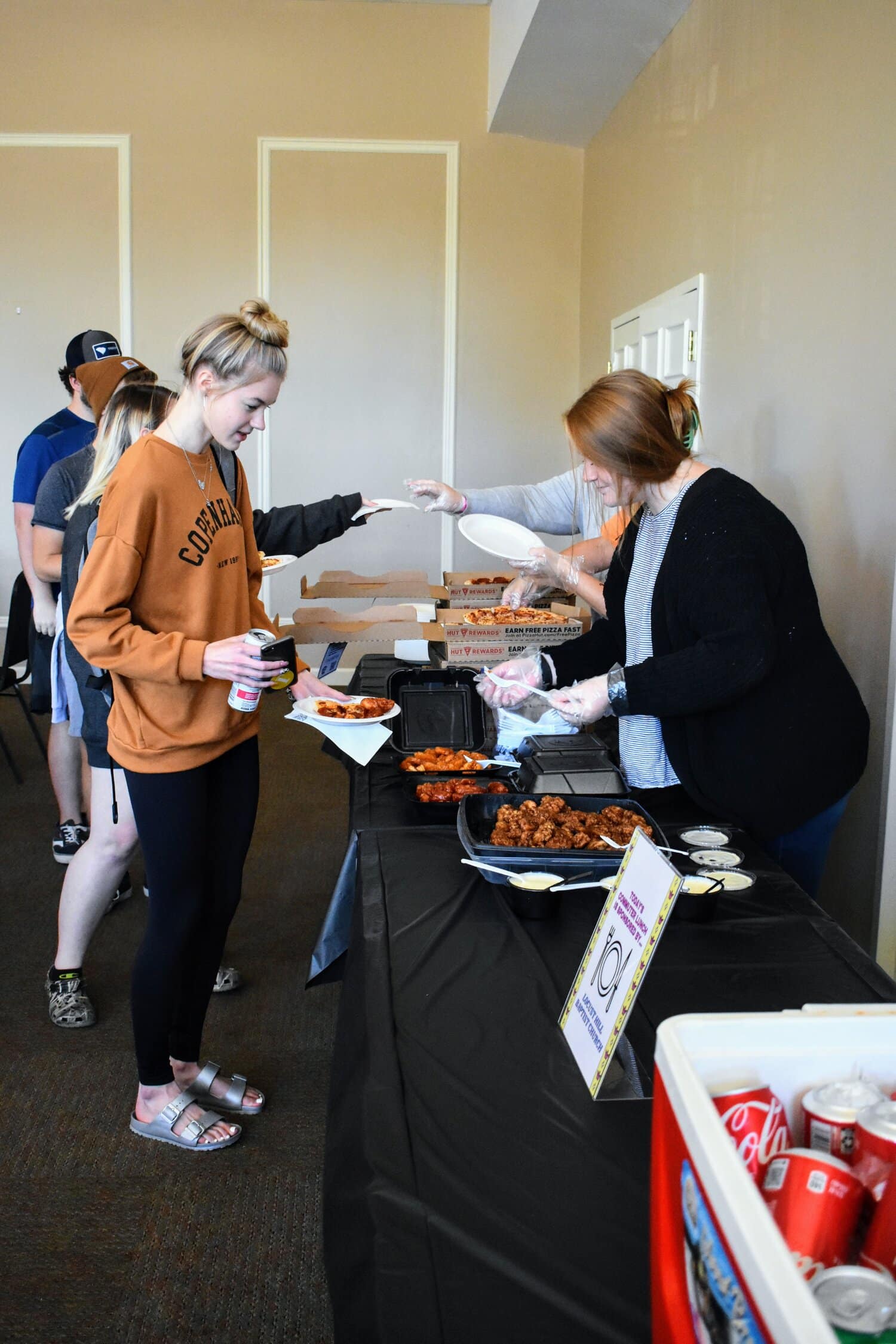 Kinslee Medlin, sophomore, serving food to Emma Fleming, freshman, at the weekly commuter lunch.