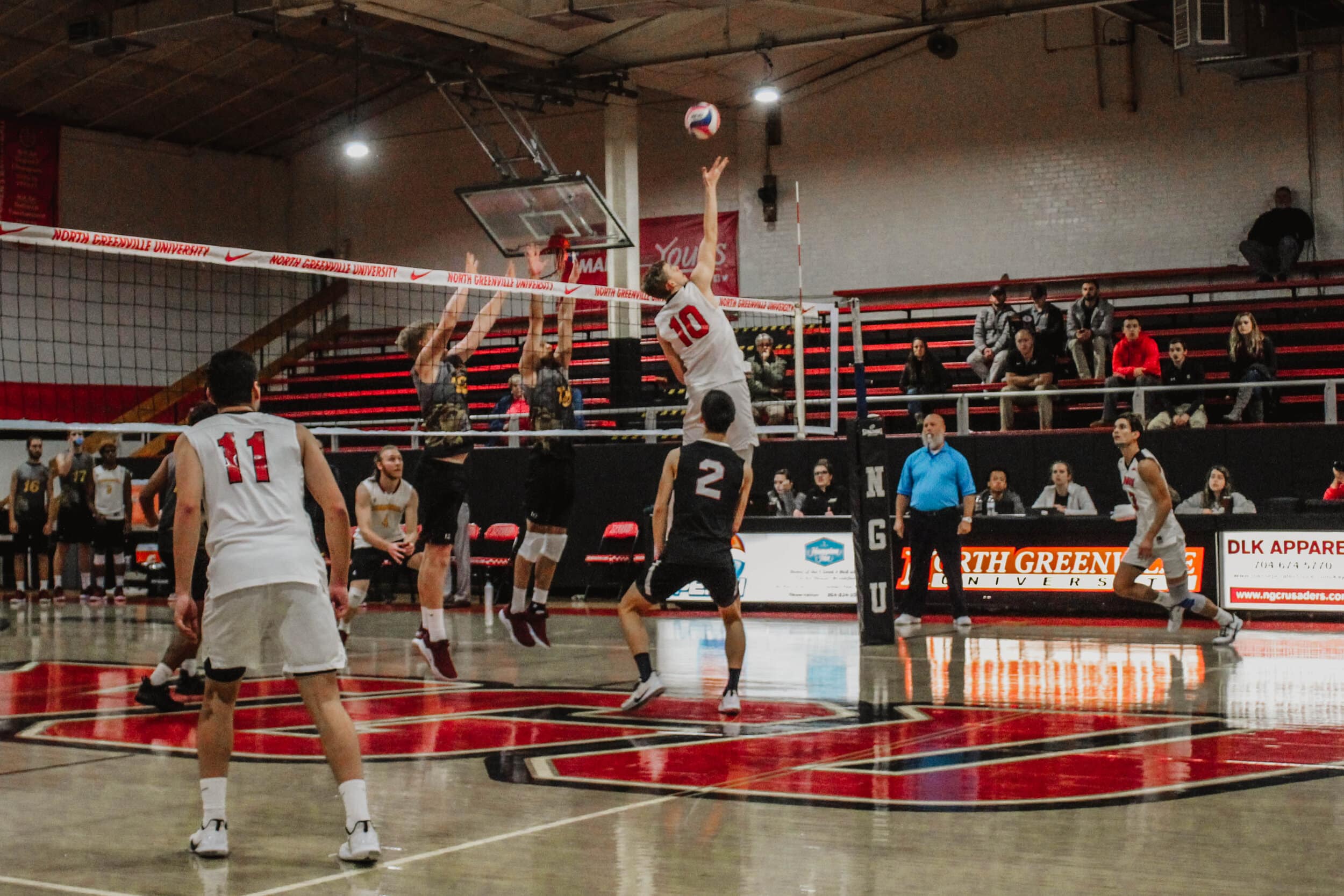 Brandon Baker (10), a junior, lunges into the air to hit the ball over the net.