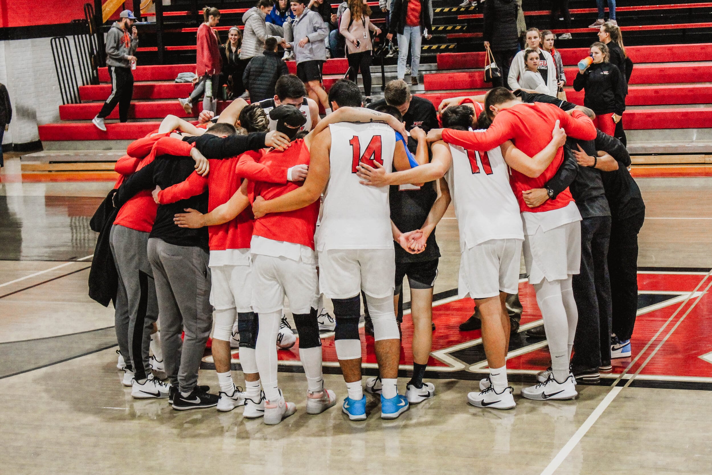 After a Crusader sweep, the players and coaches huddle together to pray after the game.