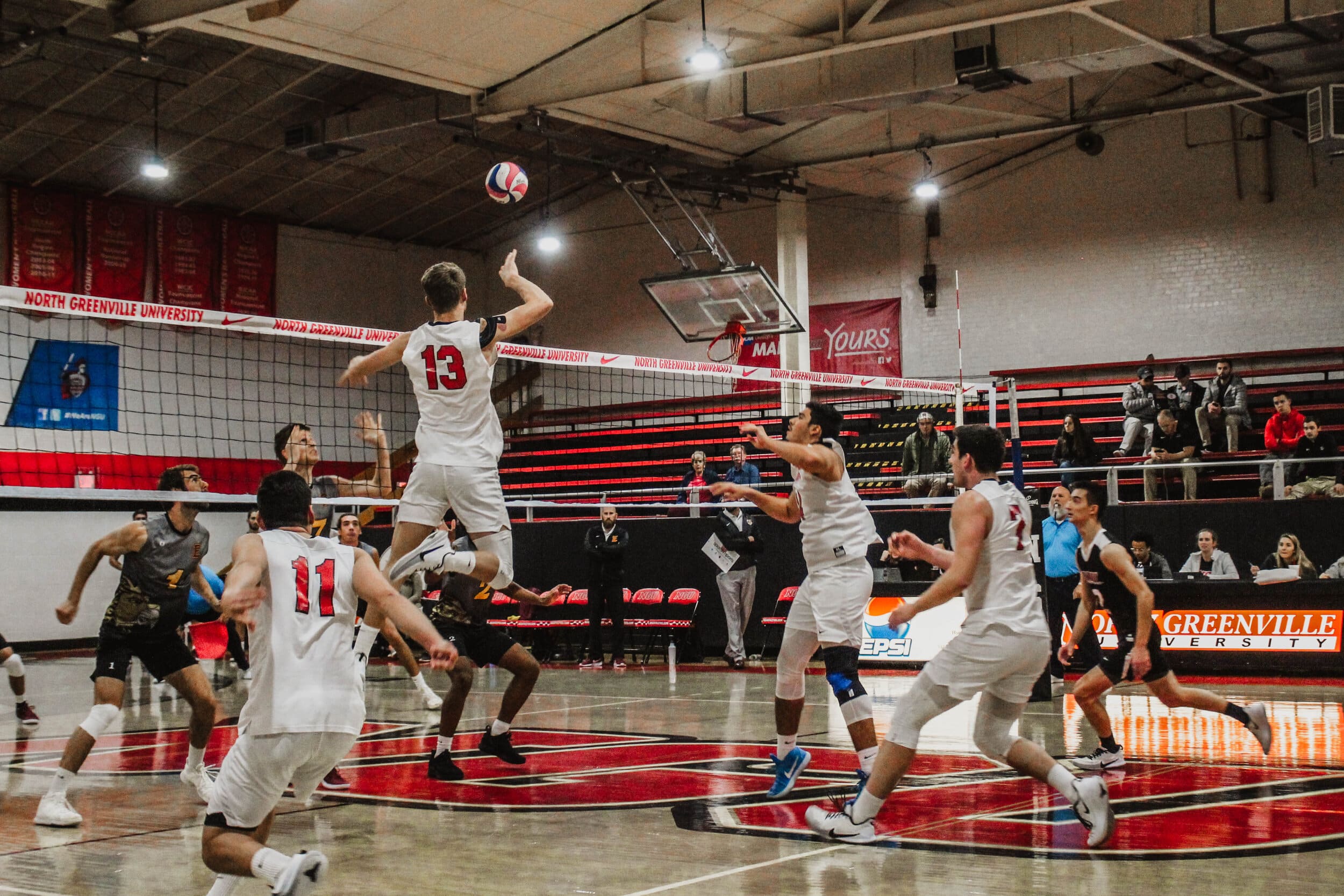 Senior Ben Hamsho (13), spikes the ball over the net, past the opposing teams blockers, for a point.