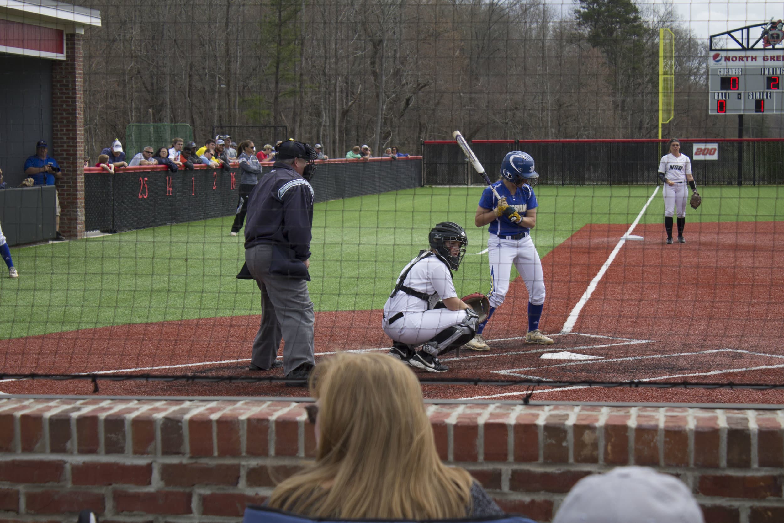 The catcher for North Greenville looks to the dugout for the pitching call.