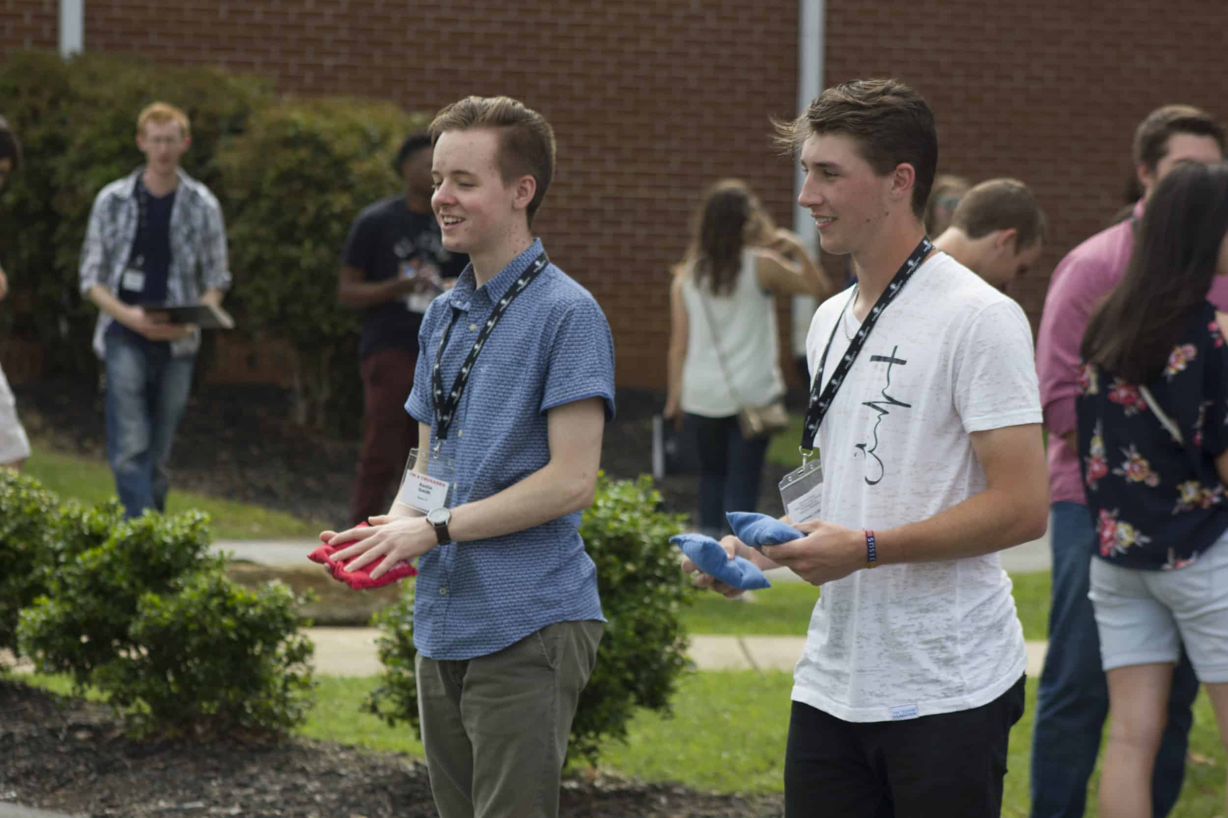 Austin Smith (left) and Ben Matthews (right) compete in a game of corn hole with other future classmates.