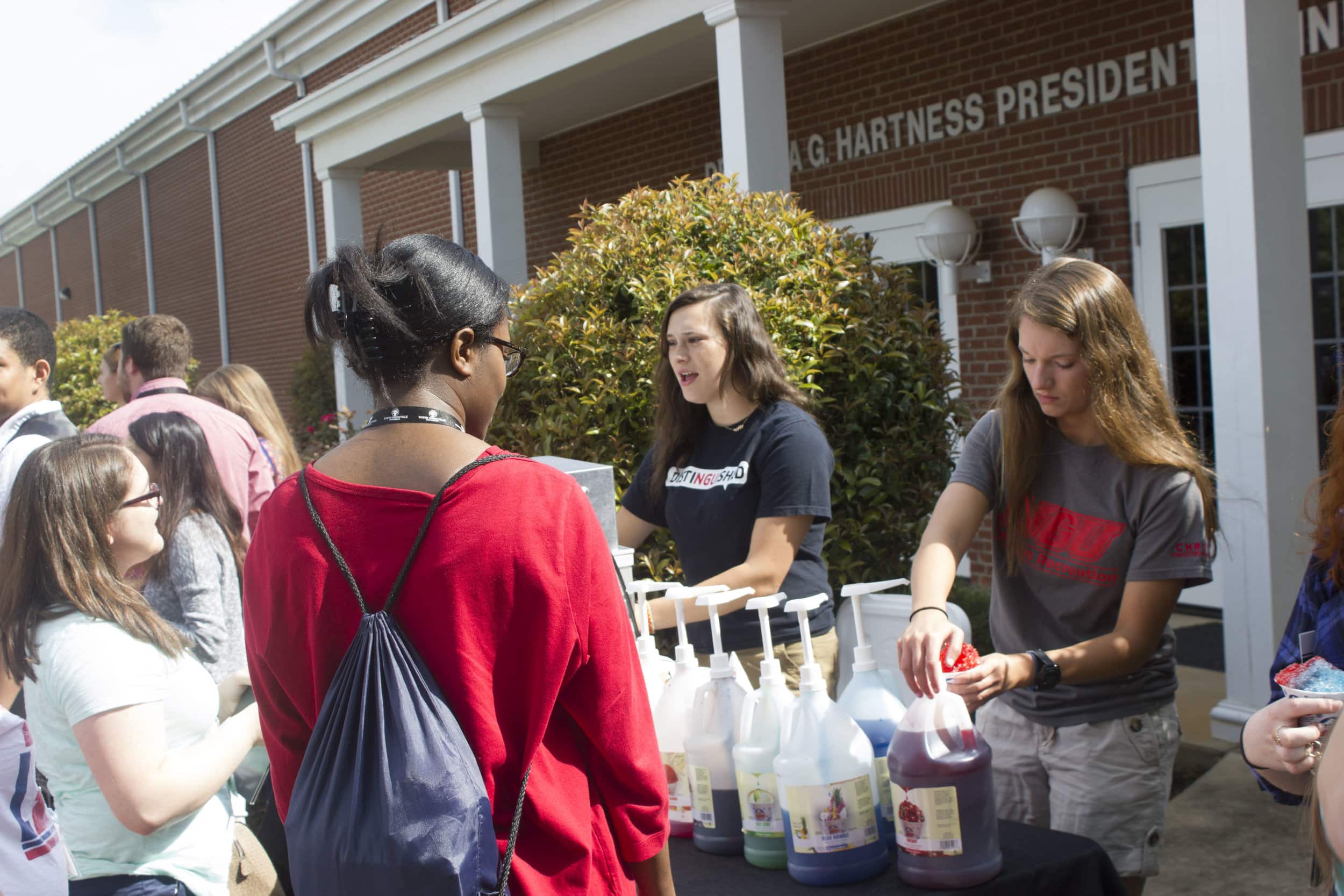 Some students in the incoming class of 2021 line up to receive a delicious snow cone served by NGU students Emily Brown and Grace Bridger.