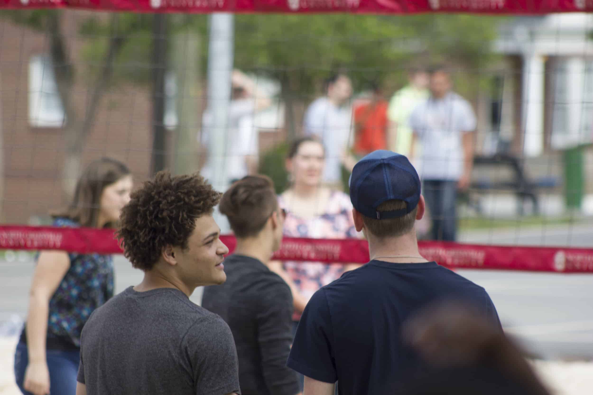 Two future crusaders converse during a sand volleyball game.