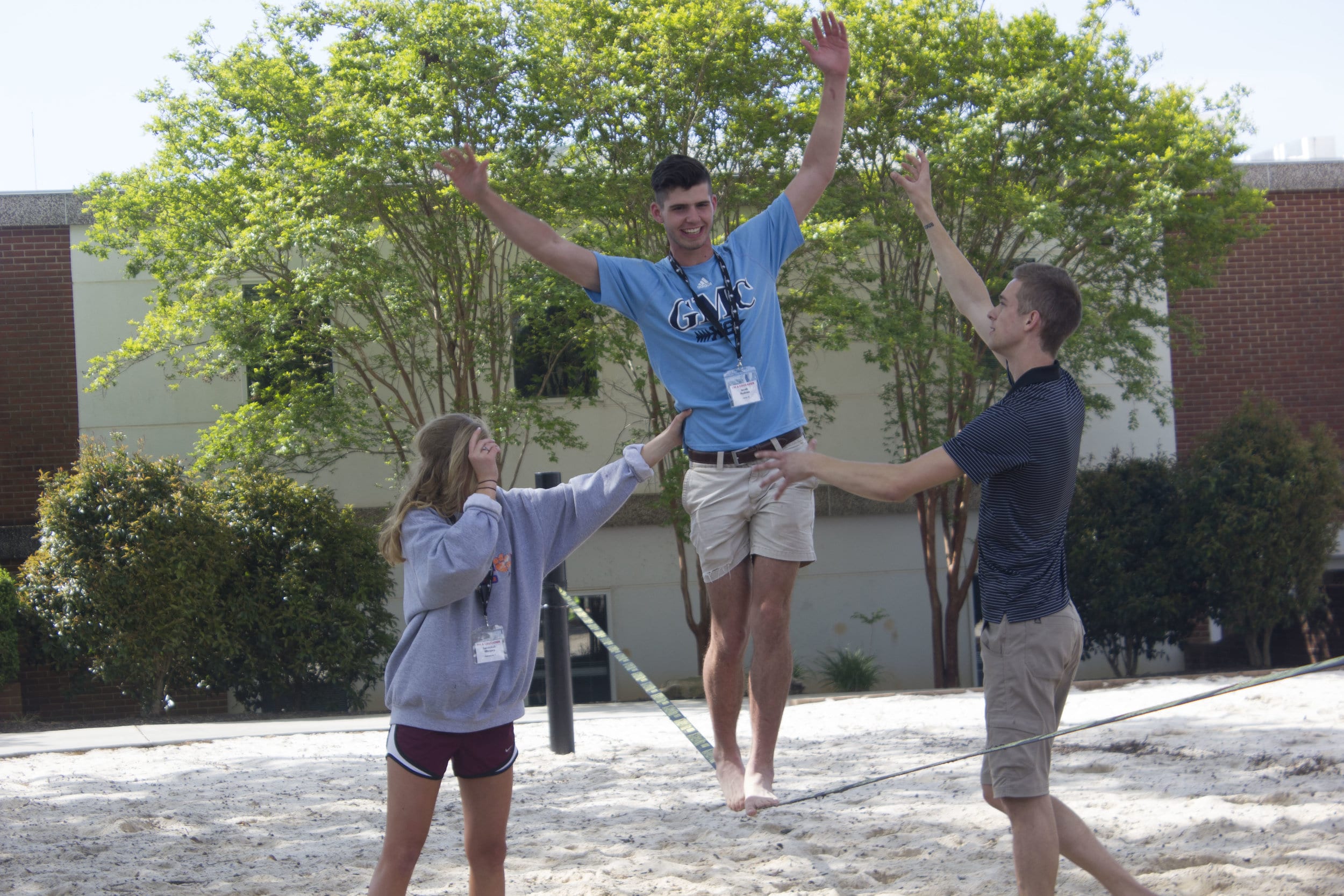 NGU's Connor McAbee (right) teaches two students from the incoming 2021 class how to slack line.