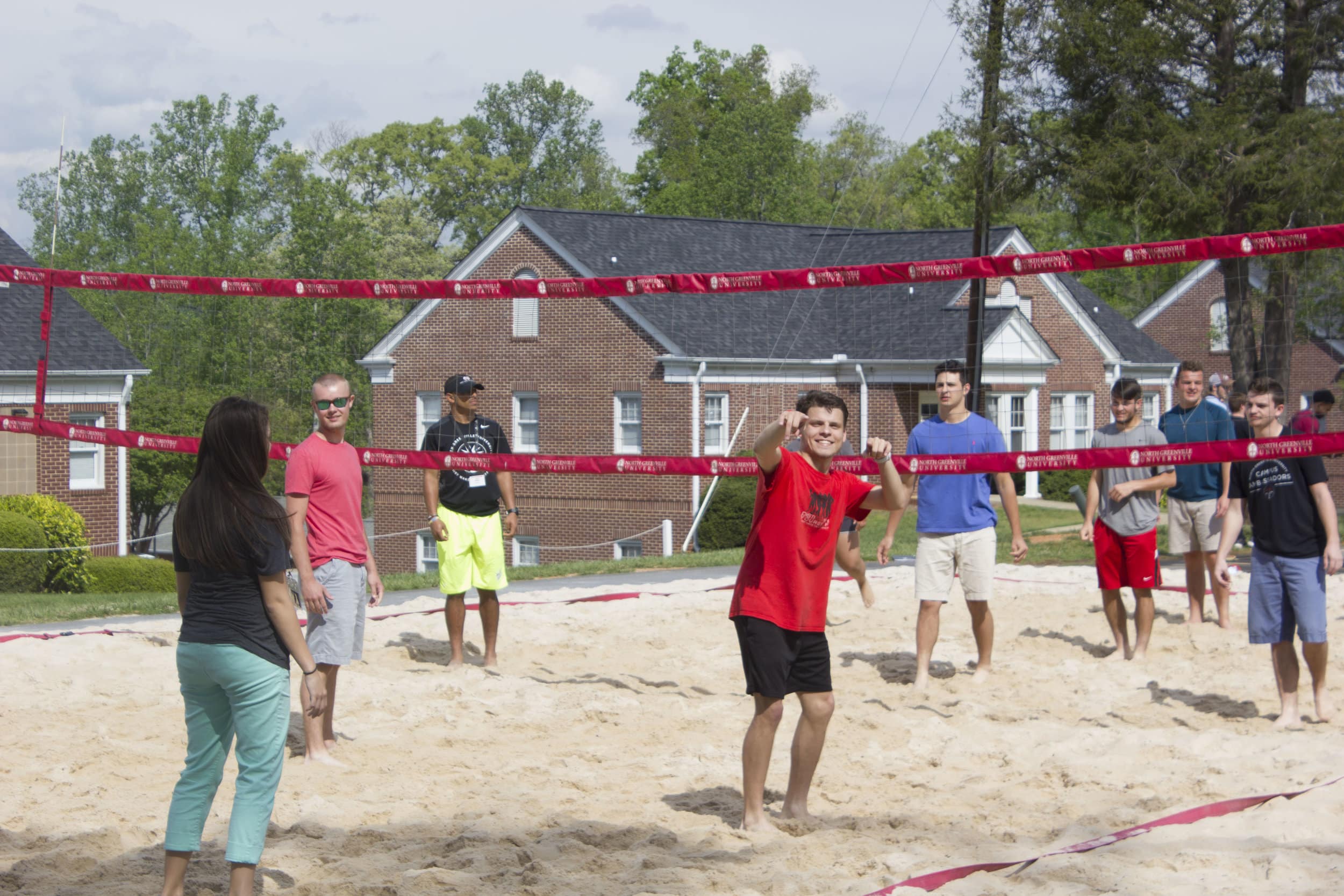 Current NGU students take part in a game of sand volleyball with the incoming freshmen class.