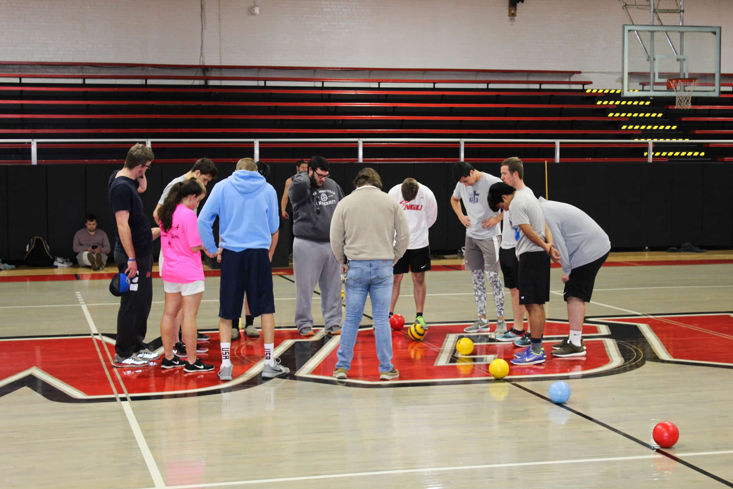 The players of both teams gather in the middle of the court before the game starts to pray together.