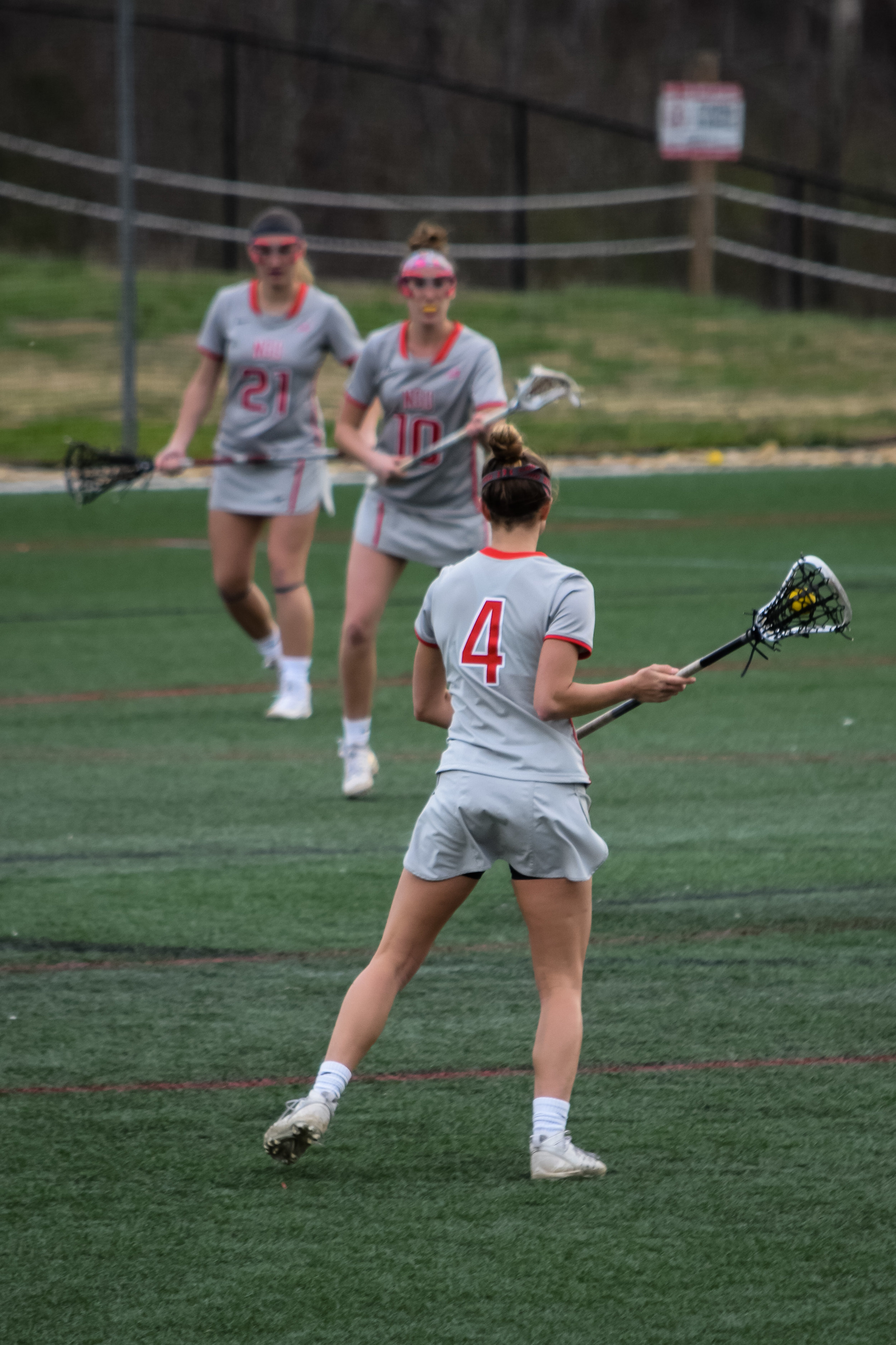 #4 Rachel Kellogg looks to her teammates,&nbsp;#10 Emily Colson and #21 Beth Farrell, to see who is open.