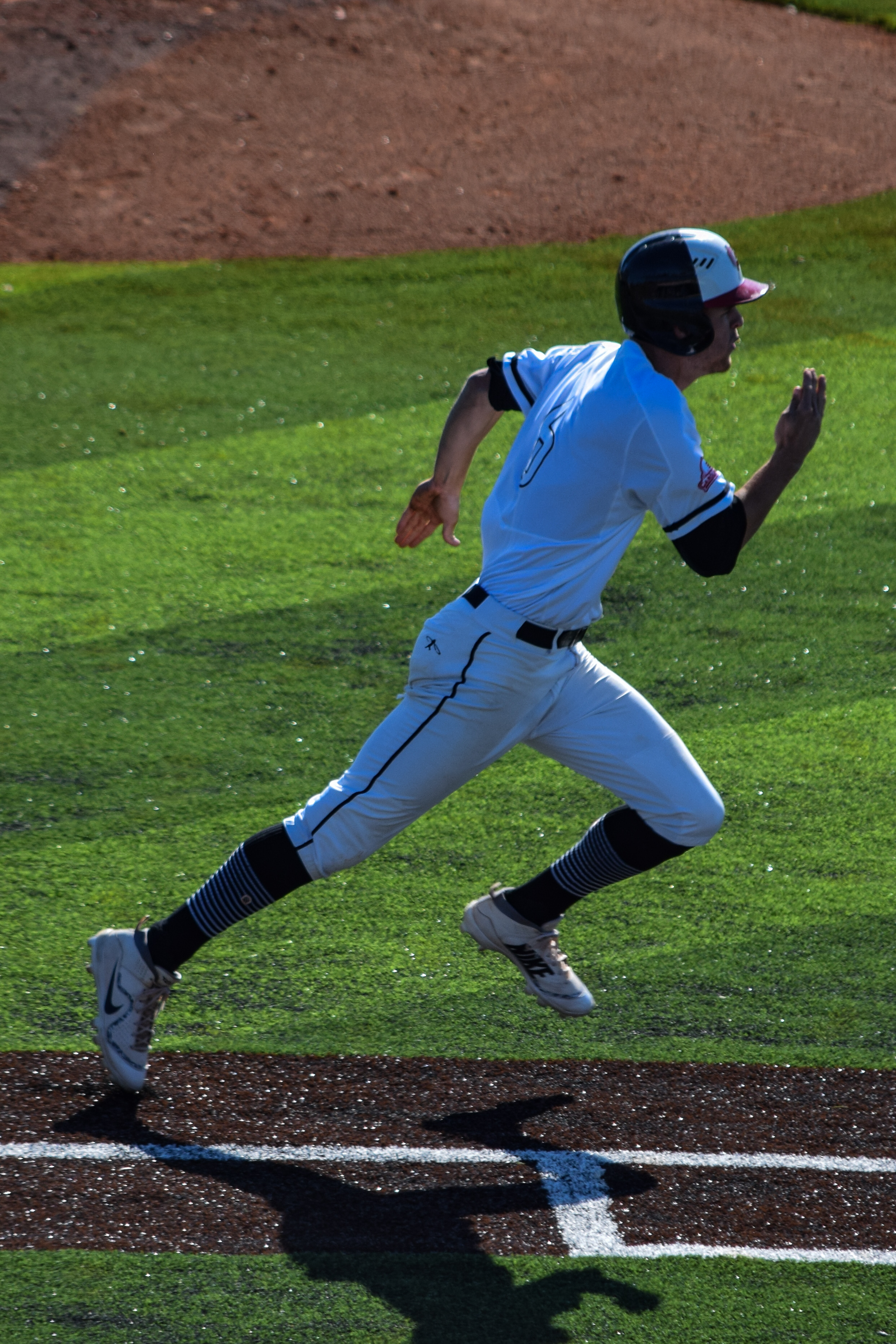 #6 Connor Grant rushes to first base in order to beat the ball and gain a base.