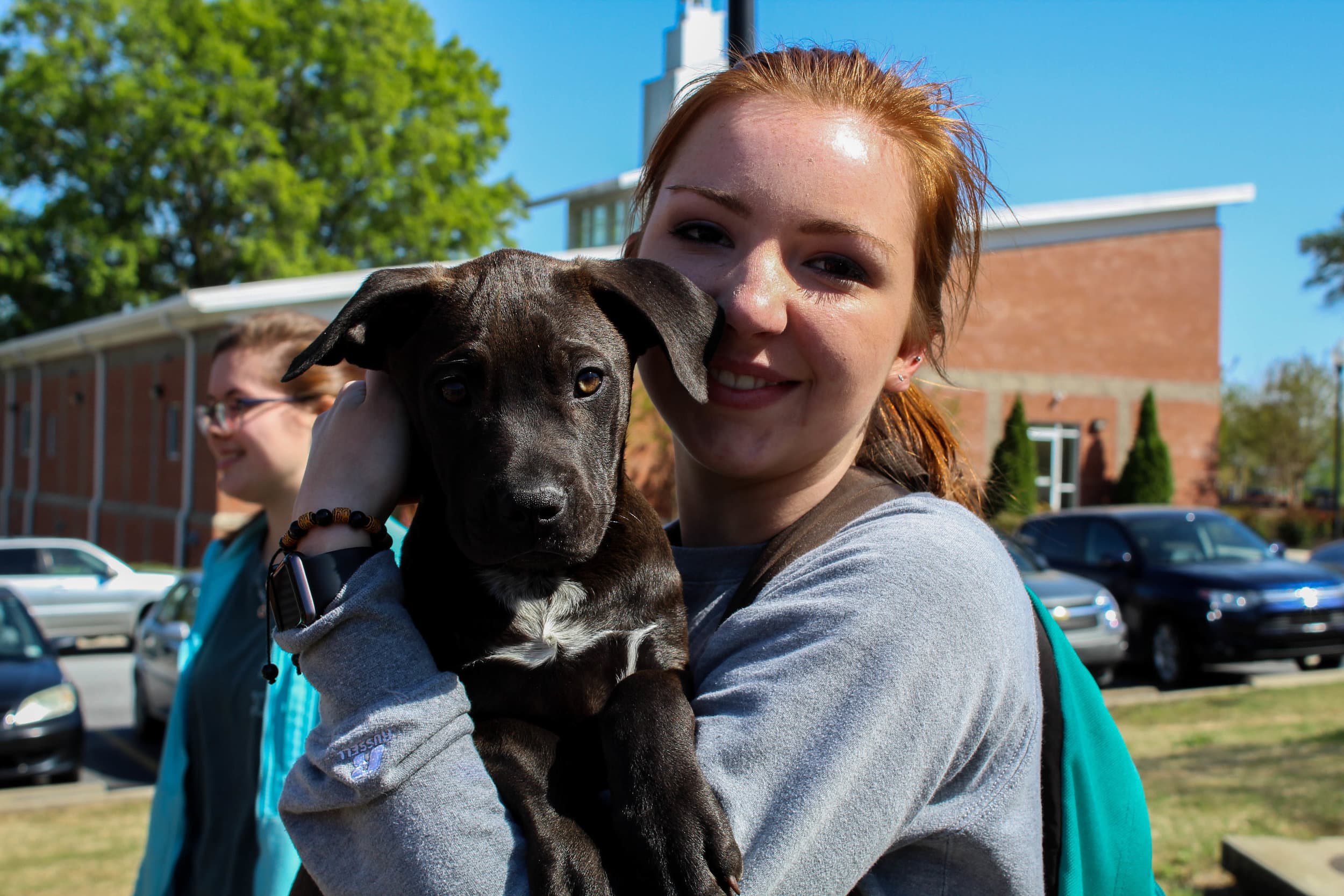 Annabrooke Heatherly, a member of the Animal Science Club, shows her love for animals as she holds one of the puppies.