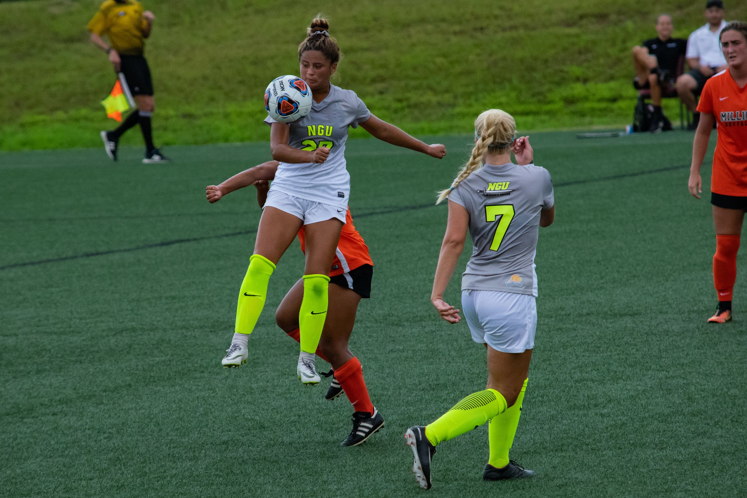 #27 Alyssa Mendez jumps in front of the opposing team to keep possession of the ball as #7 Abby Robinson stands by to help.