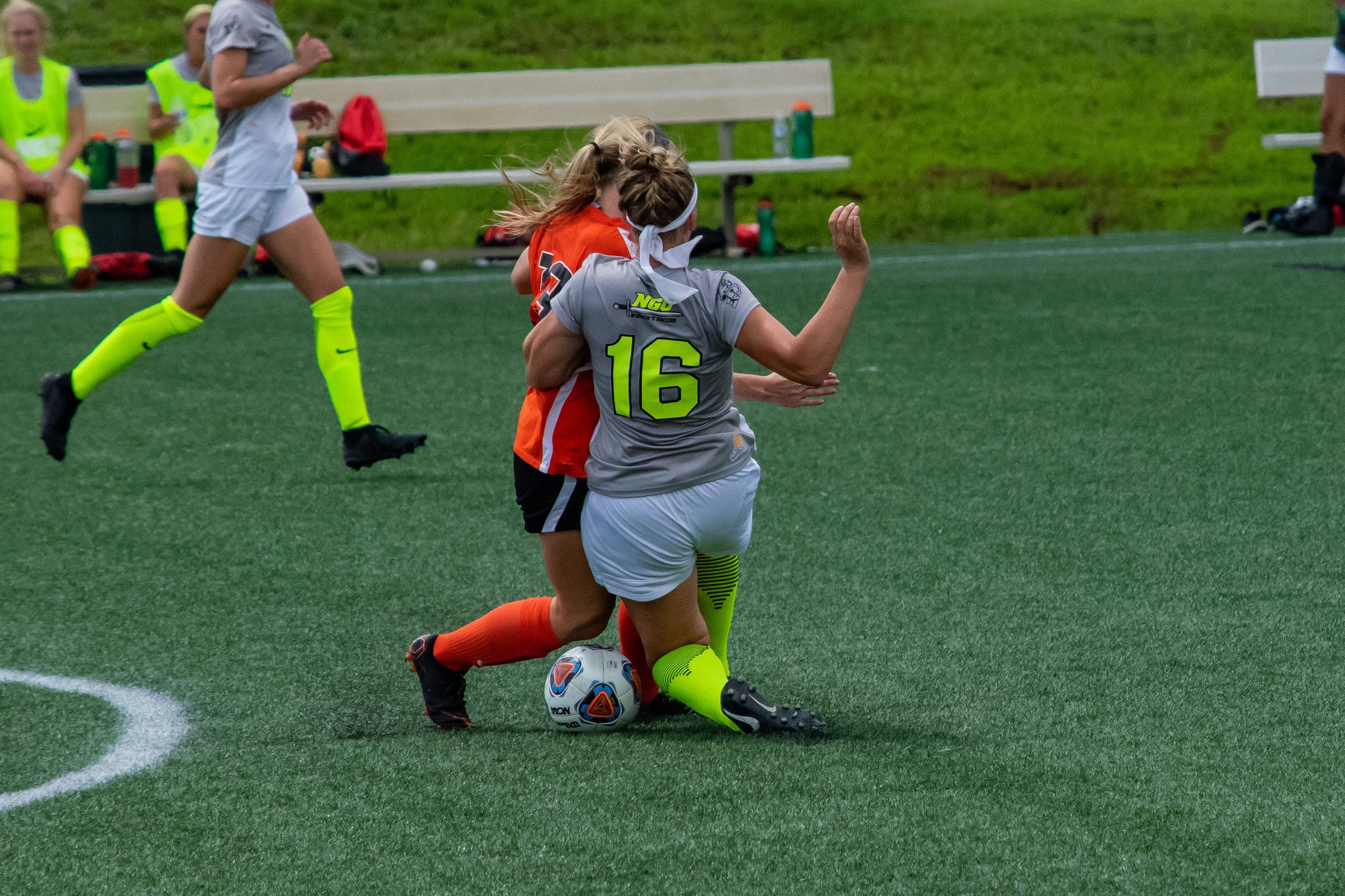 #16 Michaela Gleed runs into the opposing player trying to pass the ball to a team member.