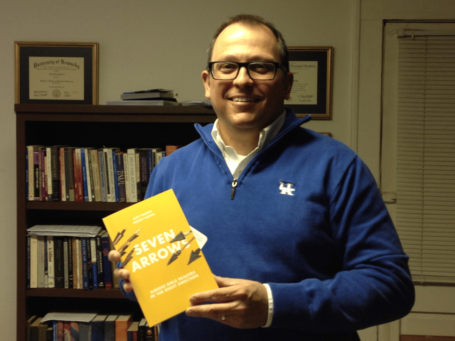 Donny Mathis, a professor of Christian Studies at NGU, proudly displays his new book "Seven Arrows: Aiming Bible Readers in the Right Direction", a comprehensive guide to studying the Scriptures.