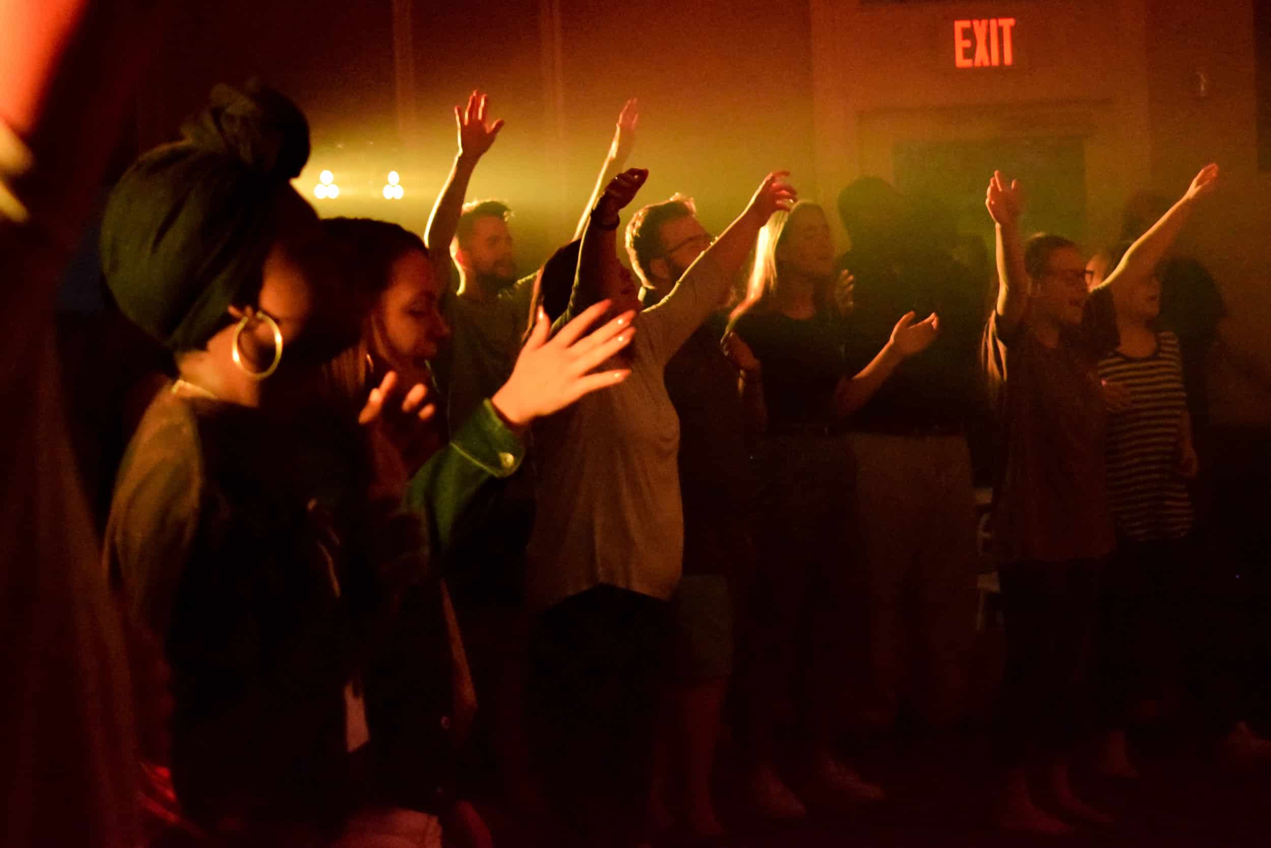 The audience feels the Spirit move as they sing along with the band and raise their hands in worship.