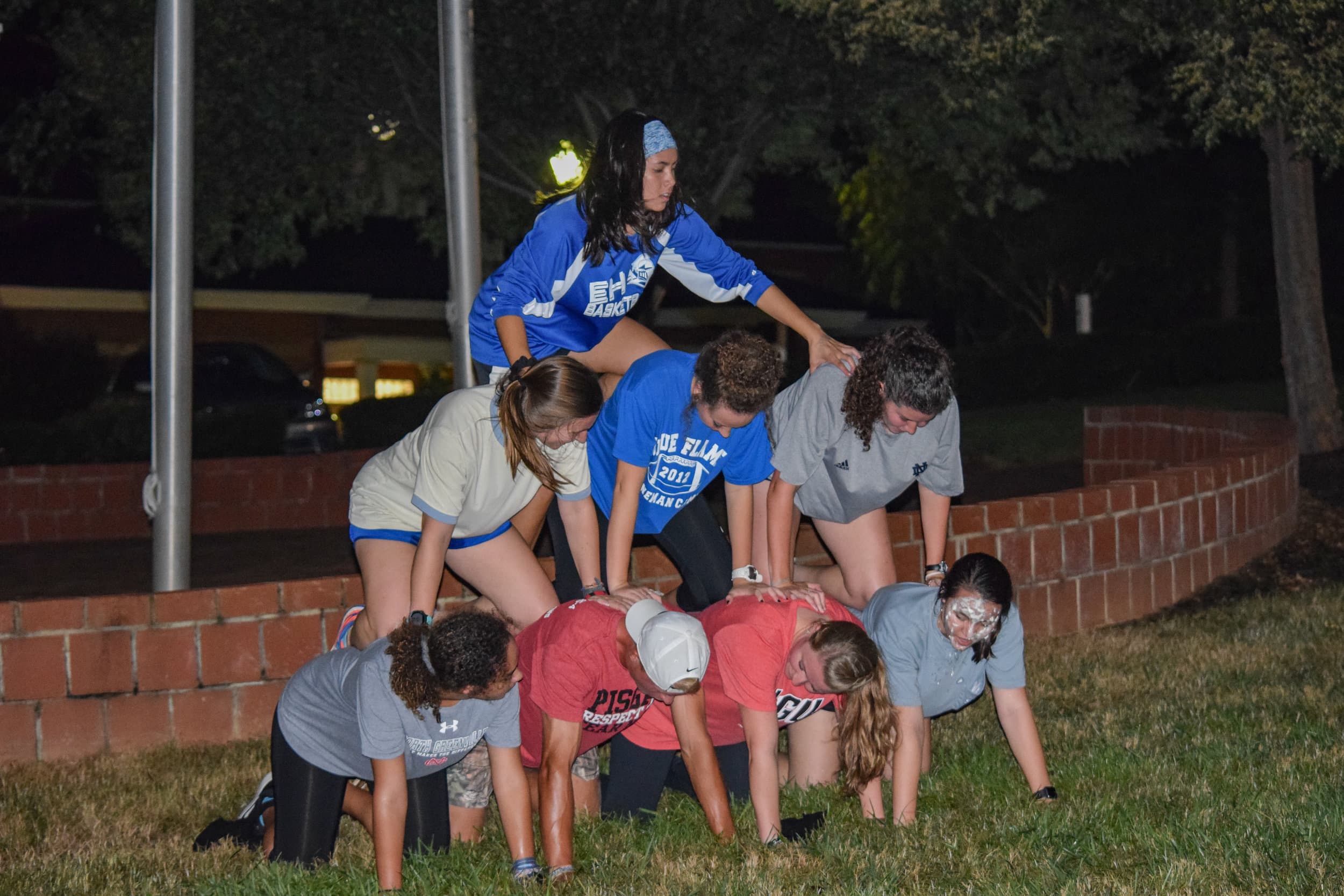 The health science club builds upon each other to form a pyramid before they can ring the bell to stop their time.
