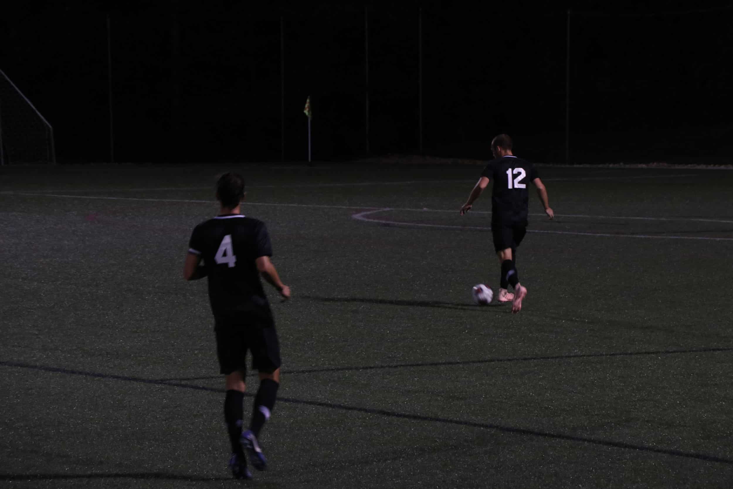 Senior, Marlon Evans (4) passes the ball to senior, Gus Johnson (12) keeping it away from other team.