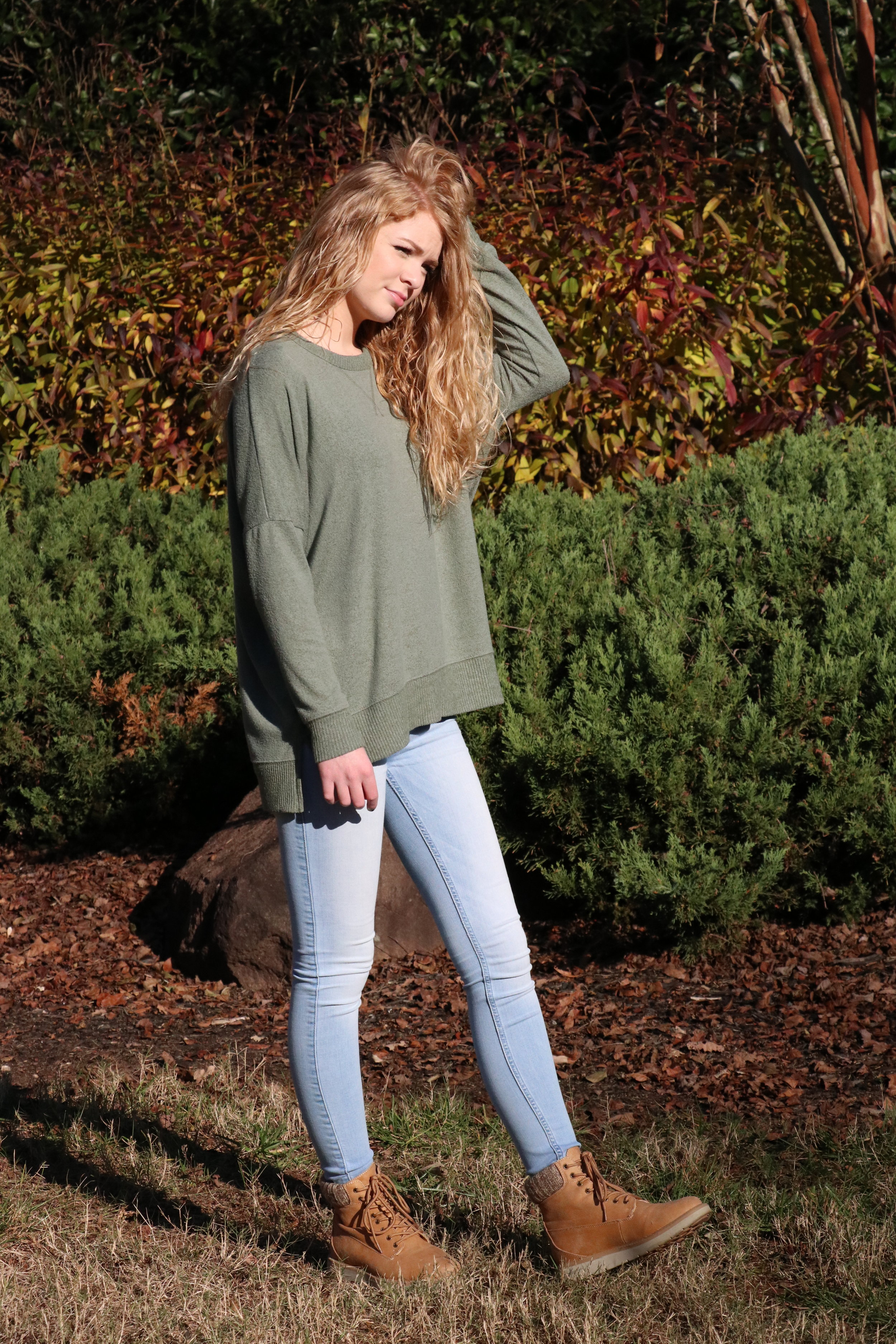 Taylor Loughry, Sophomore, goes with a green loose sweater over light washed jeans and some light brown combat boots.