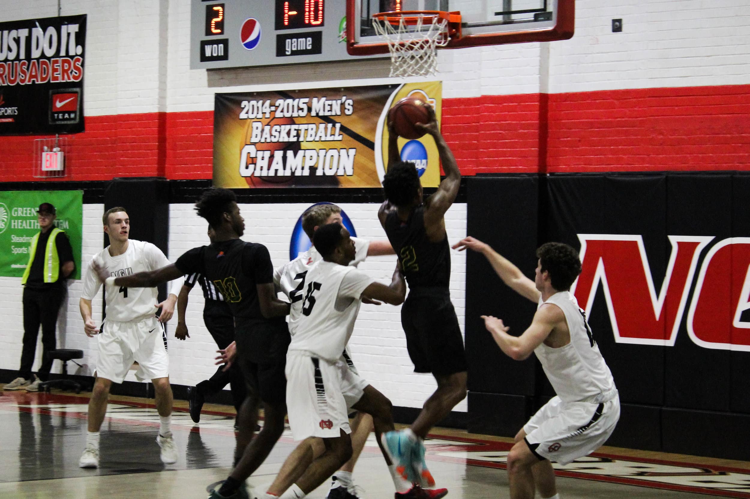 Freshman Joe Conley (24), freshman Caleb Arrington (10) and sophomore Ryan Mobley (15) defend a Lees-McRae player as he goes up for a layup.