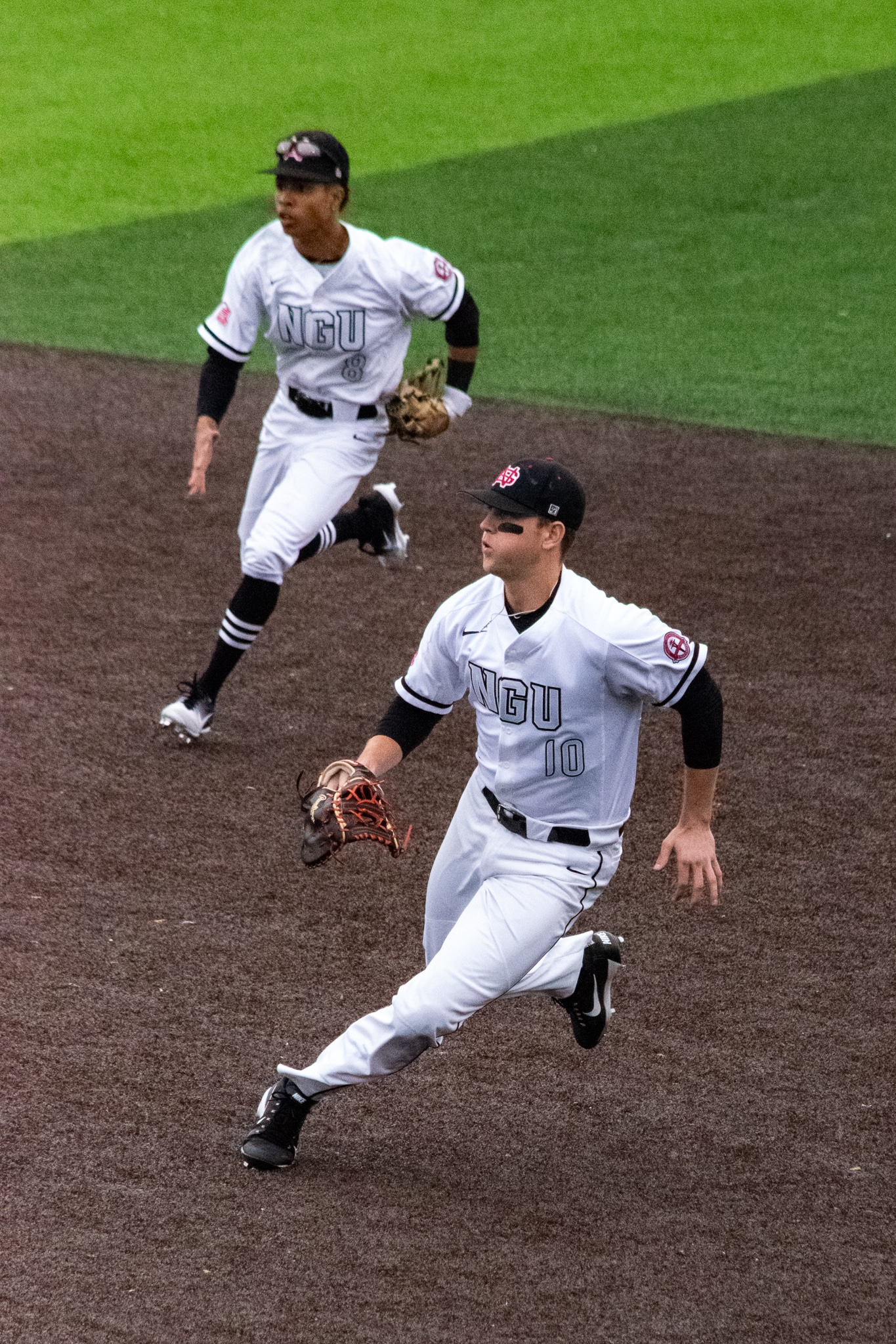 Senior Adam Sasser (10) rushes towards first base after his opponent hits the ball as his teammate sophomore Jeremy Whitehead (8) runs behind him to back him up.