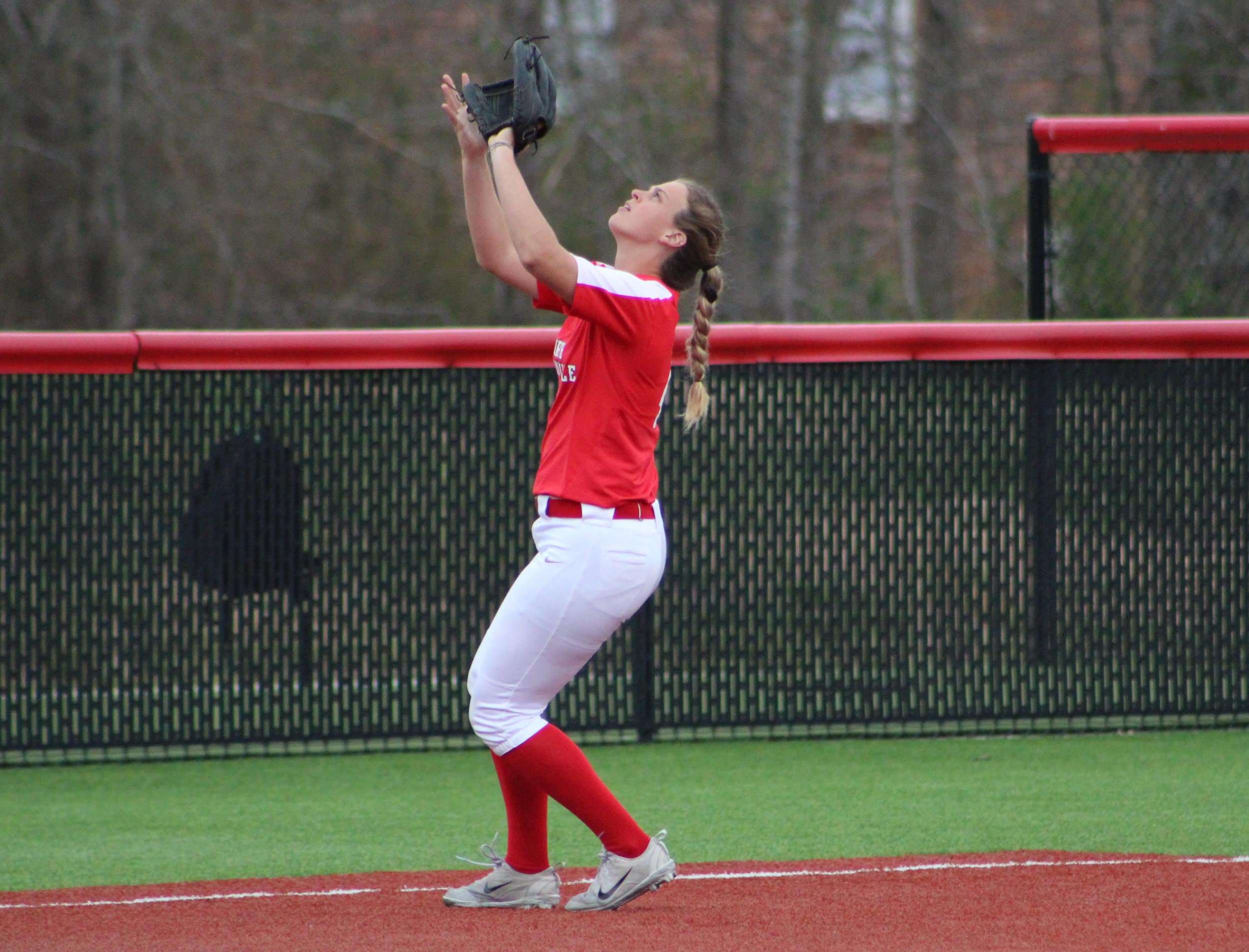 Short stop, Stone (4), catches a fly ball hit by the opposing team.