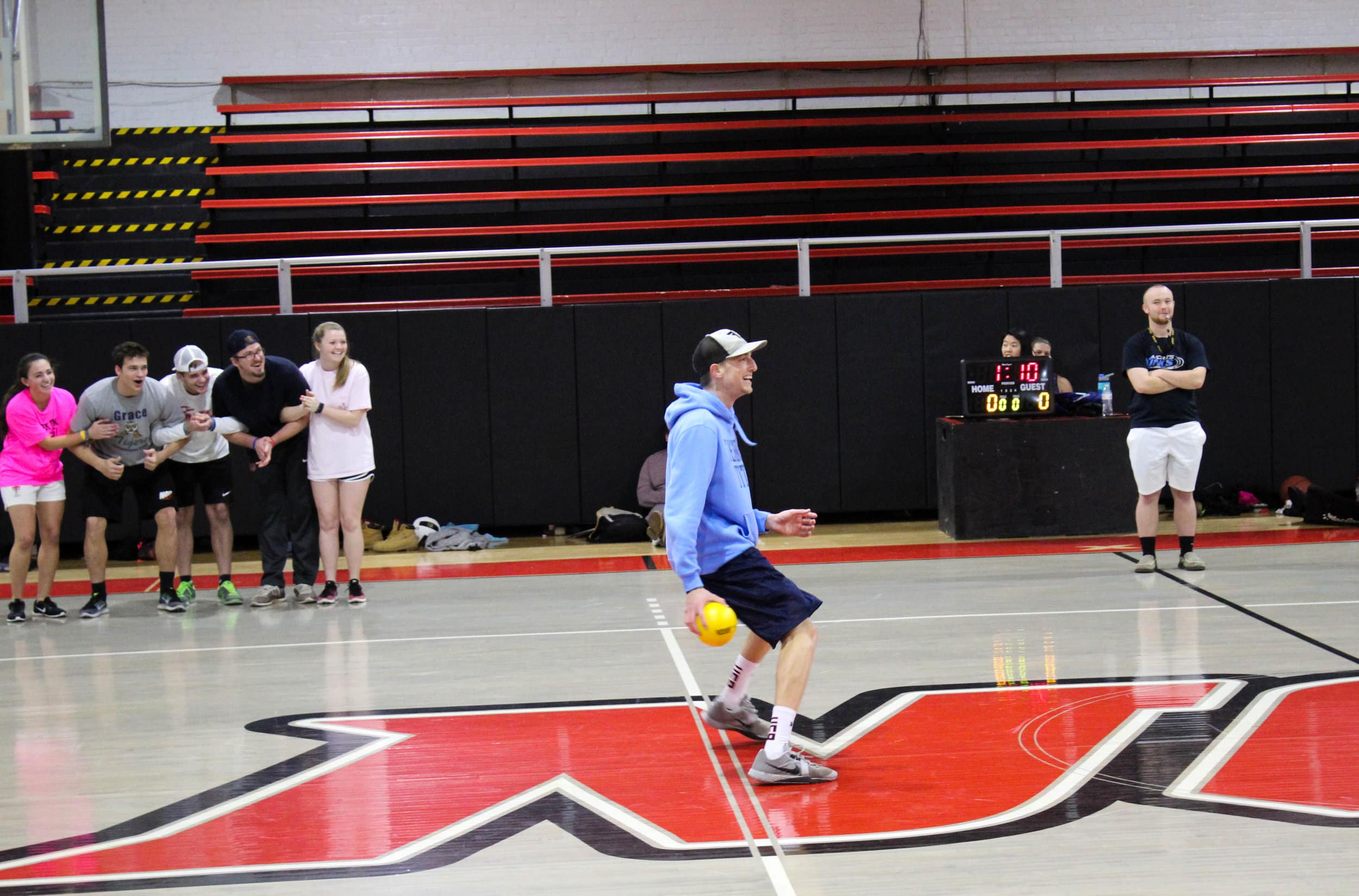 Junior Adam Daniel backs up from his opponent to avoid getting hit as his teammates link arms and show support by cheering him on.