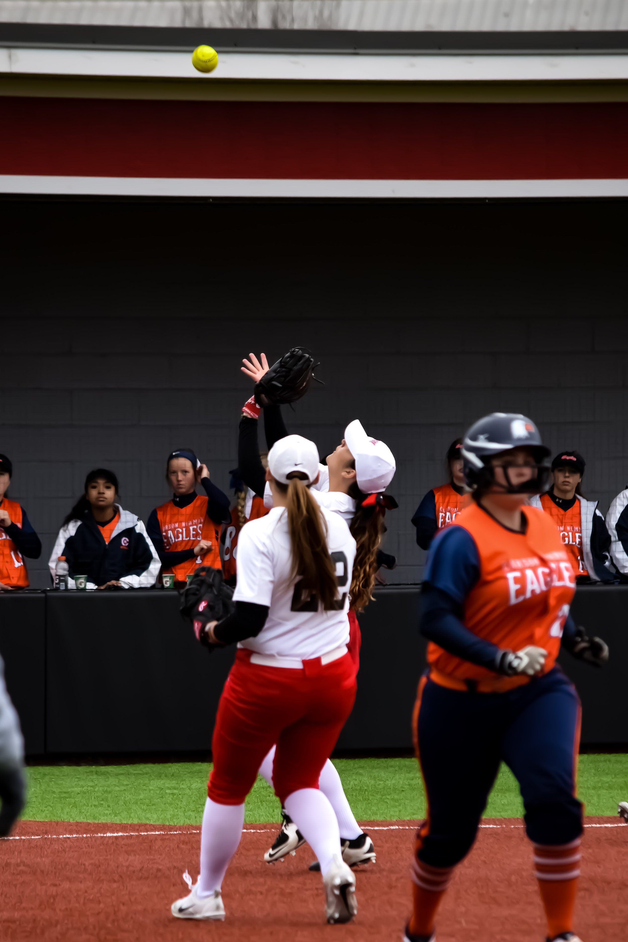 NGU's pitcher #3 Amanda Coffrin and first baseman #22 Jaelin Griffin rush to catch the pop fly to gain another out.&nbsp;