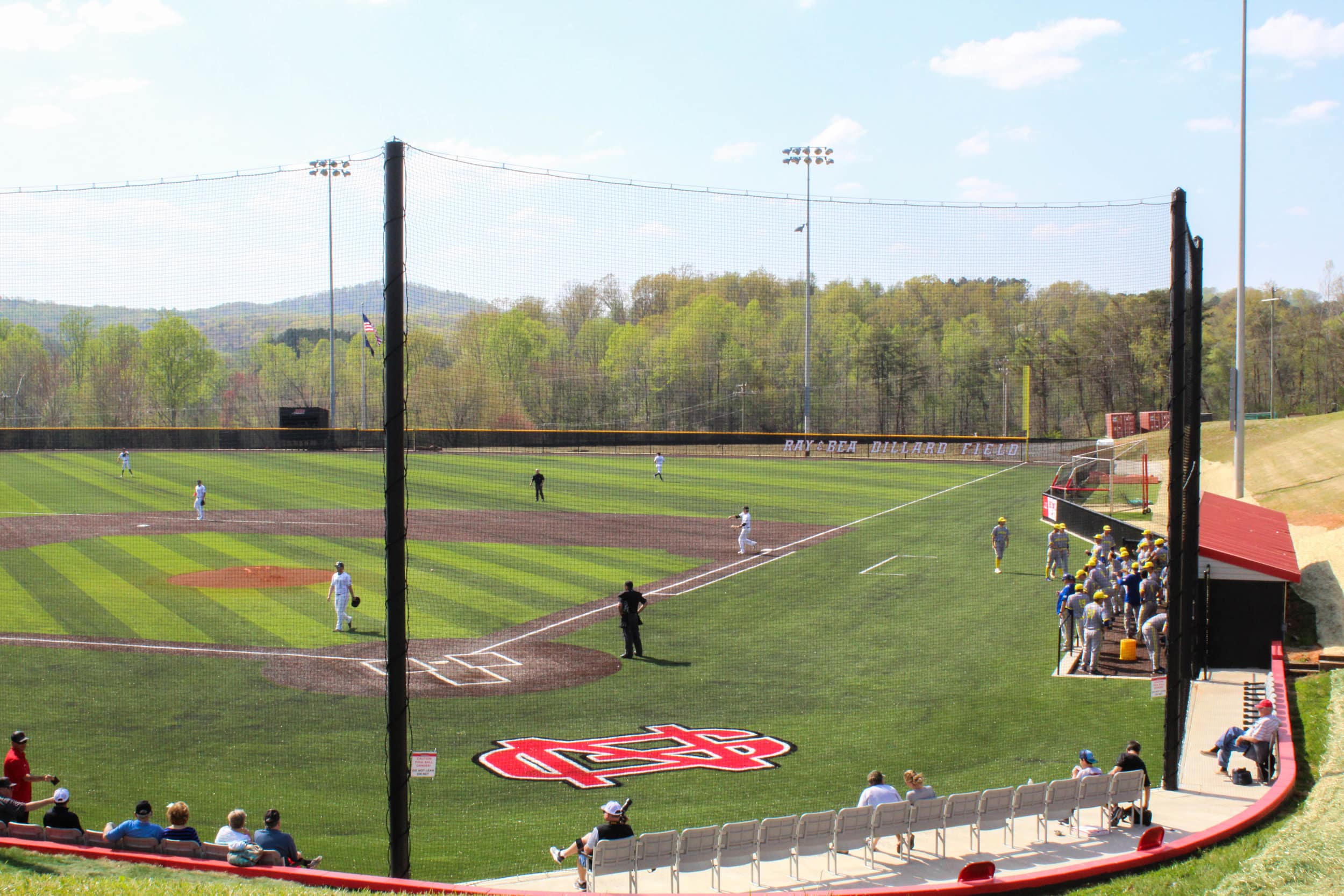 The NGU mens baseball players warm up before the other team comes to the plate.