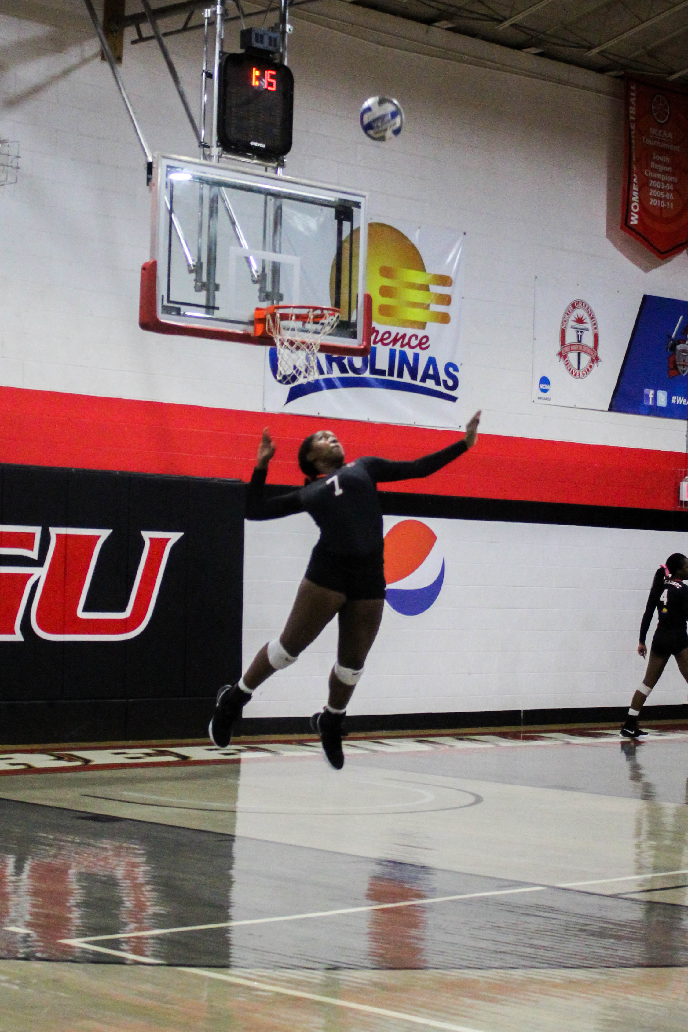 Senior Johna Robbins (7) jumps to serve the ball over the net.