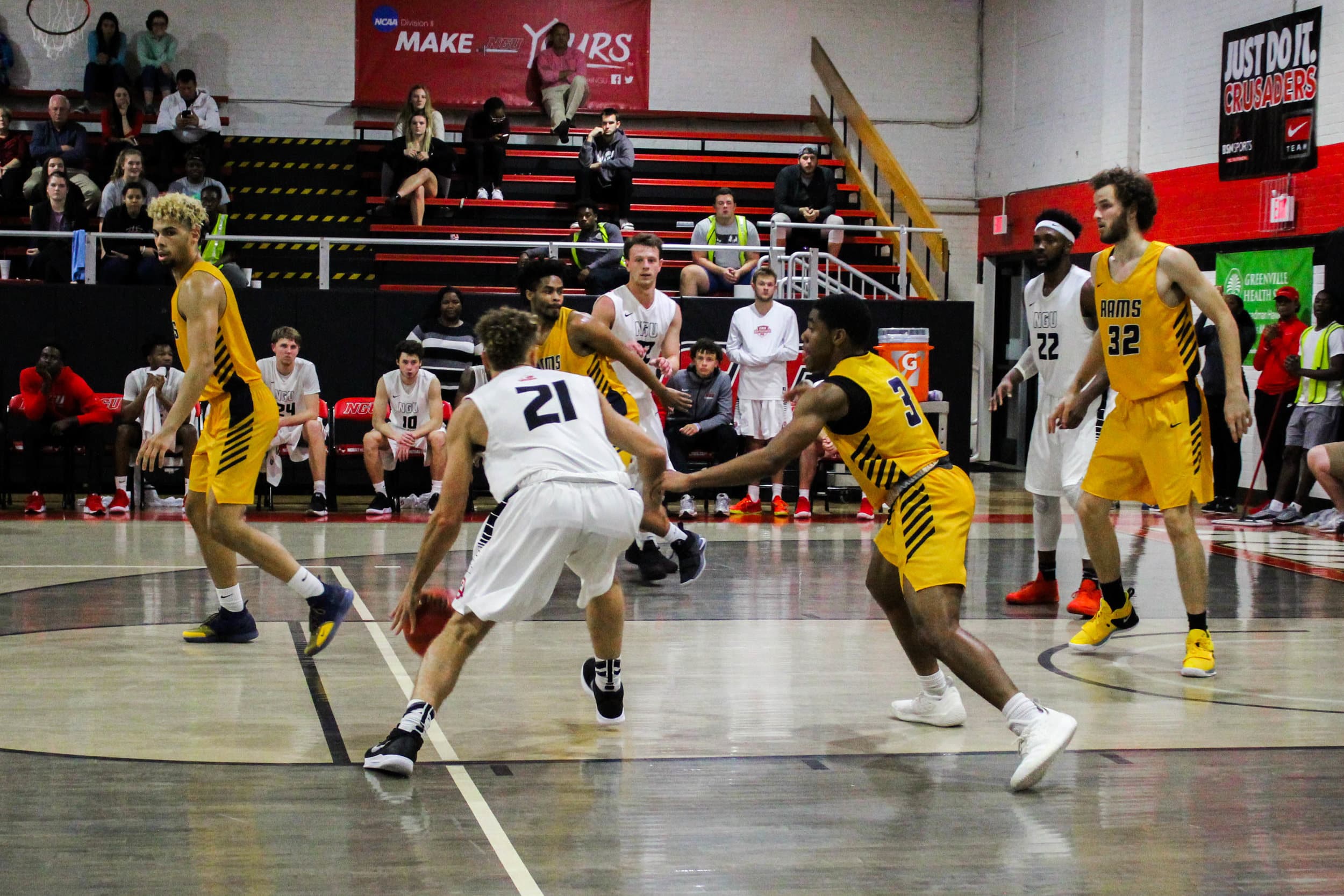 AJ Myers (21), a sophomore guard, dribbles the ball toward the basket.