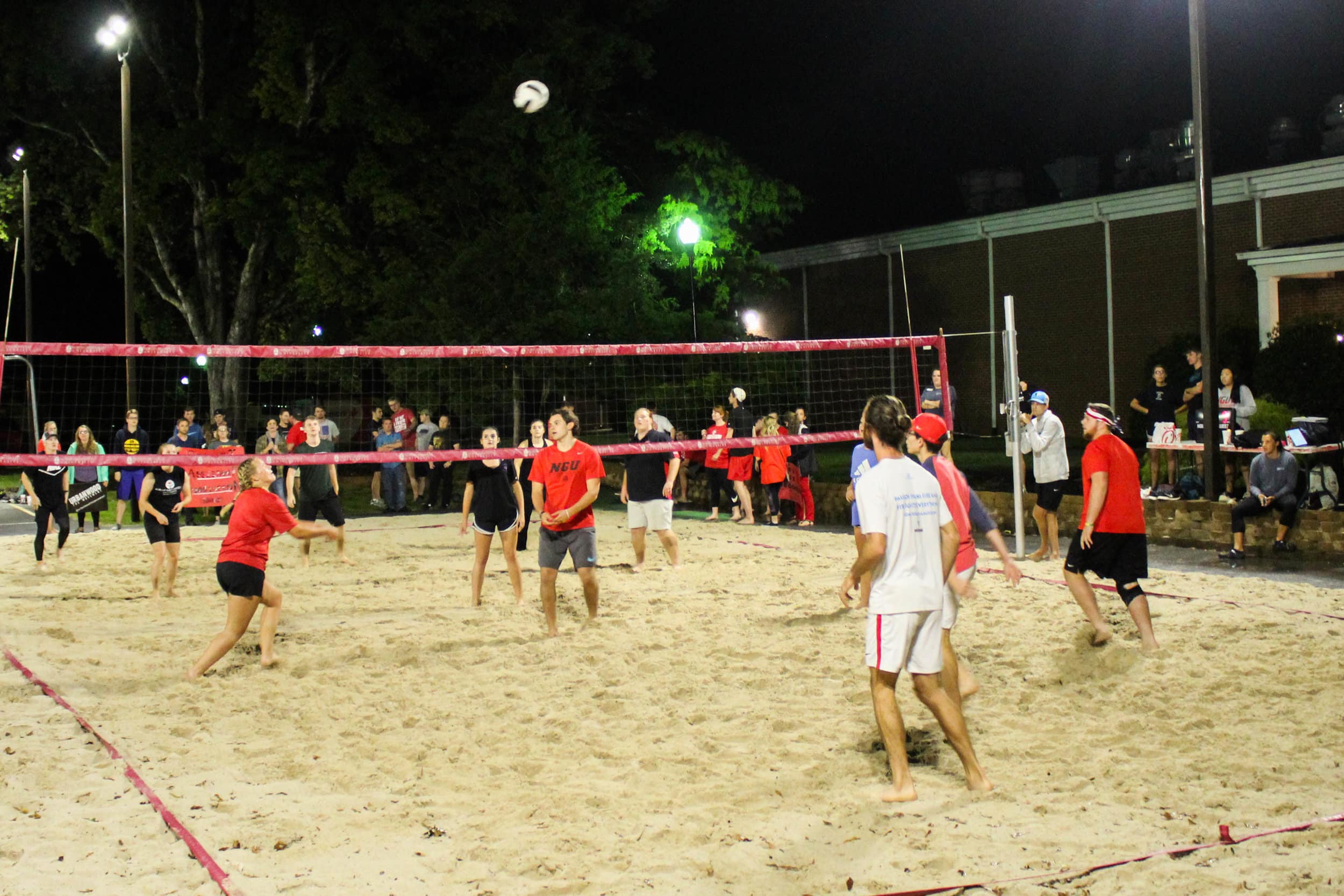 A member of the Fellowship of Christian Athletes ministry squats trying to hit the ball in a game against the Resident Assistant Association.