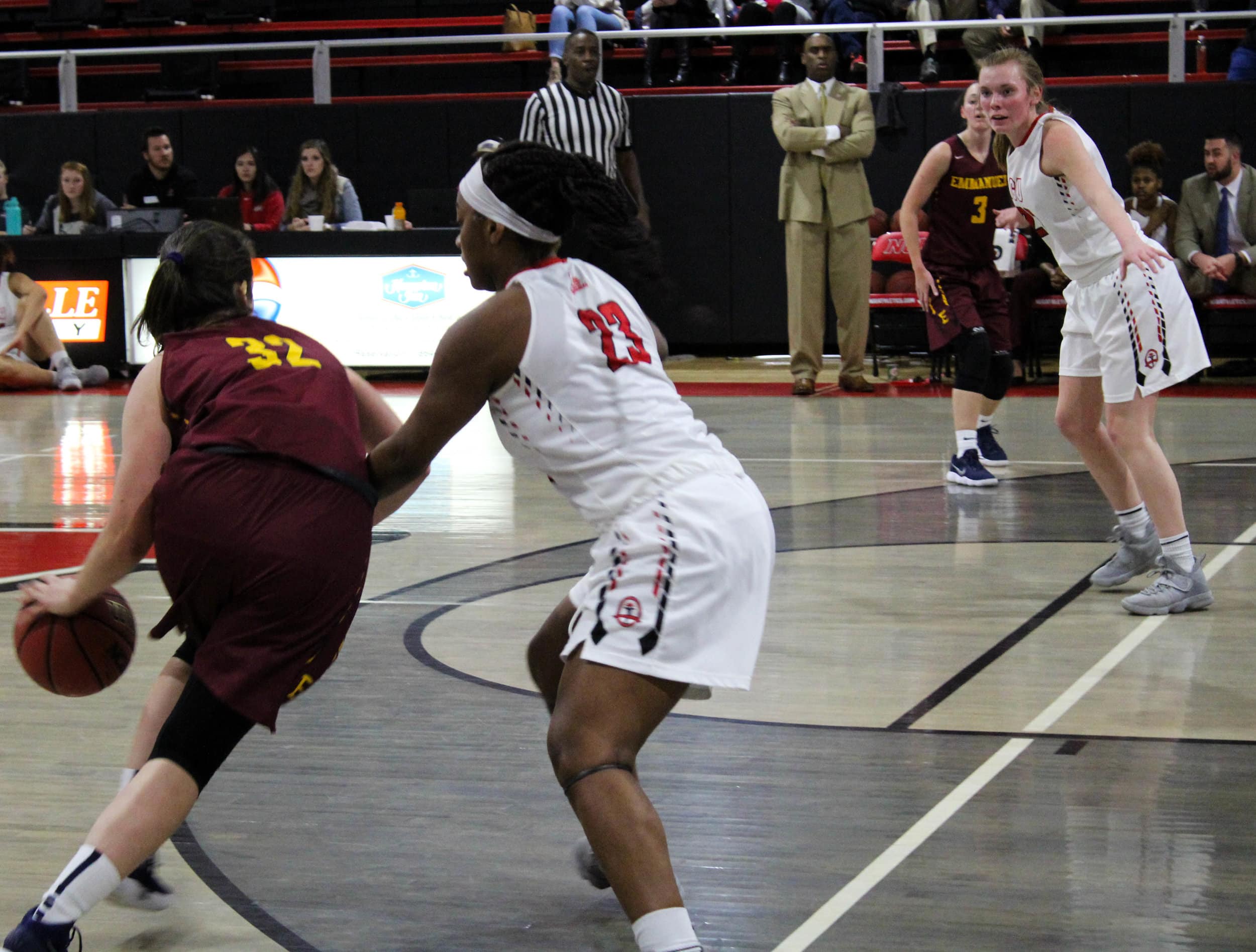 Tyana Sanders (23) guards Emmanuels point guard as she attempts to drive towards the basket.