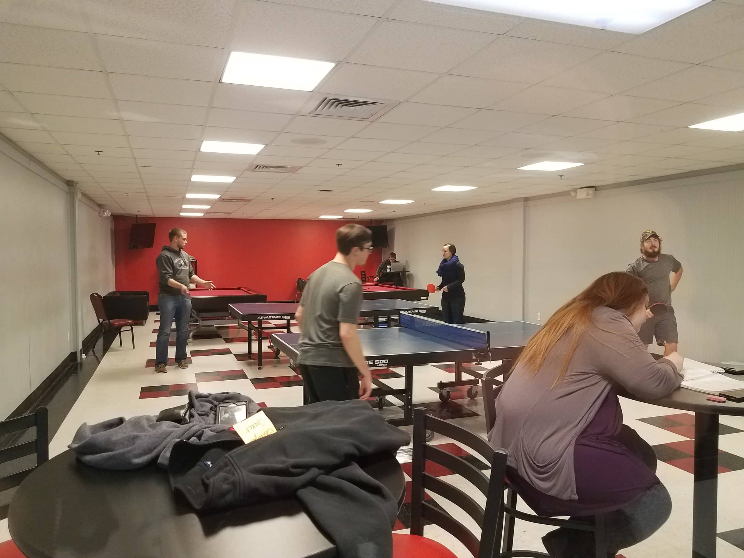 Landon Miller, Eric Guin, Karissa Sundt and Jason Howard play table tennis in the Game Room.