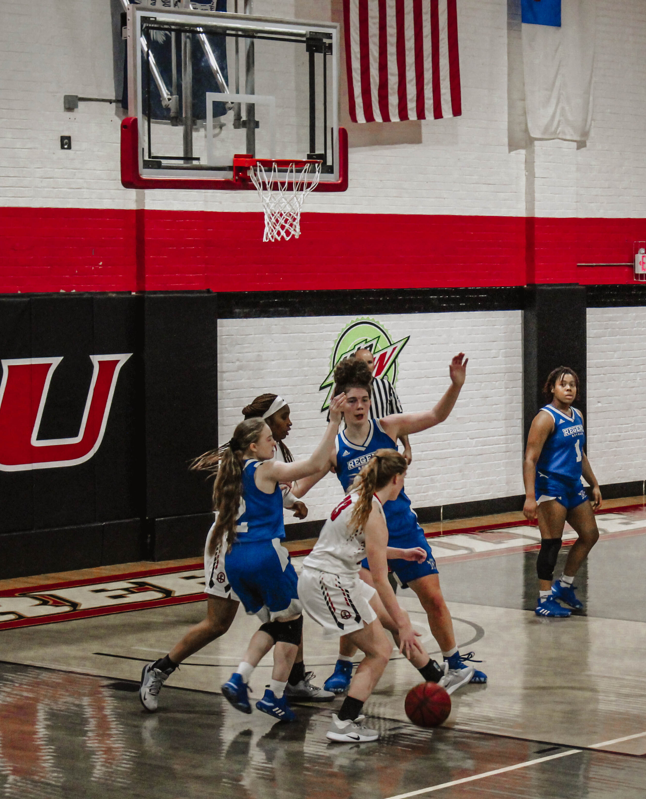 Sophomore guard Sarah Cline (33) drives the ball toward the basket as two Regent players defend her.