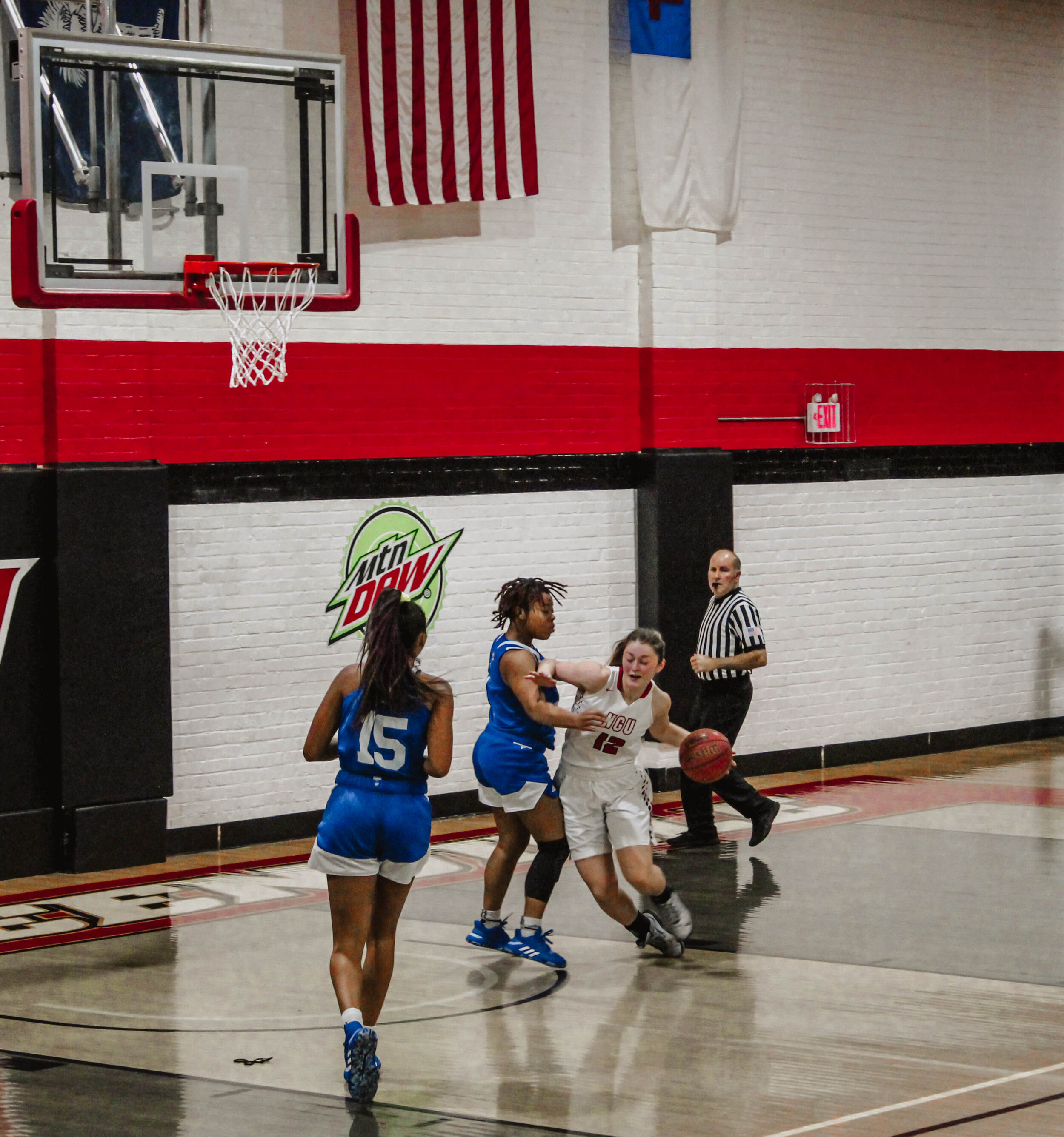 Senior Ayano Shelton (12), dribbles around a defender toward the basket.