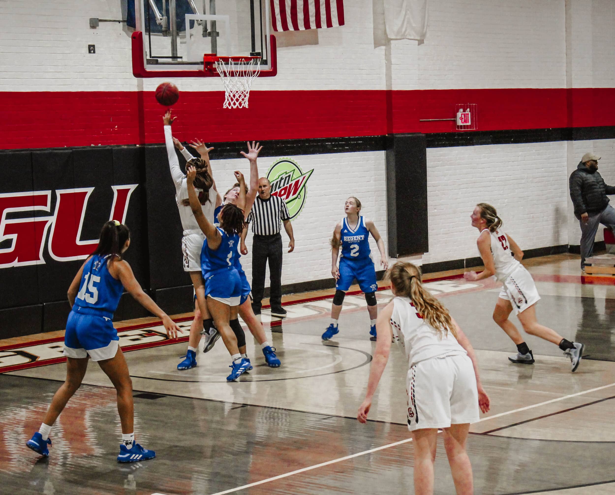 As two Regent players defend her, Chelsea Martin (24) takes a layup.