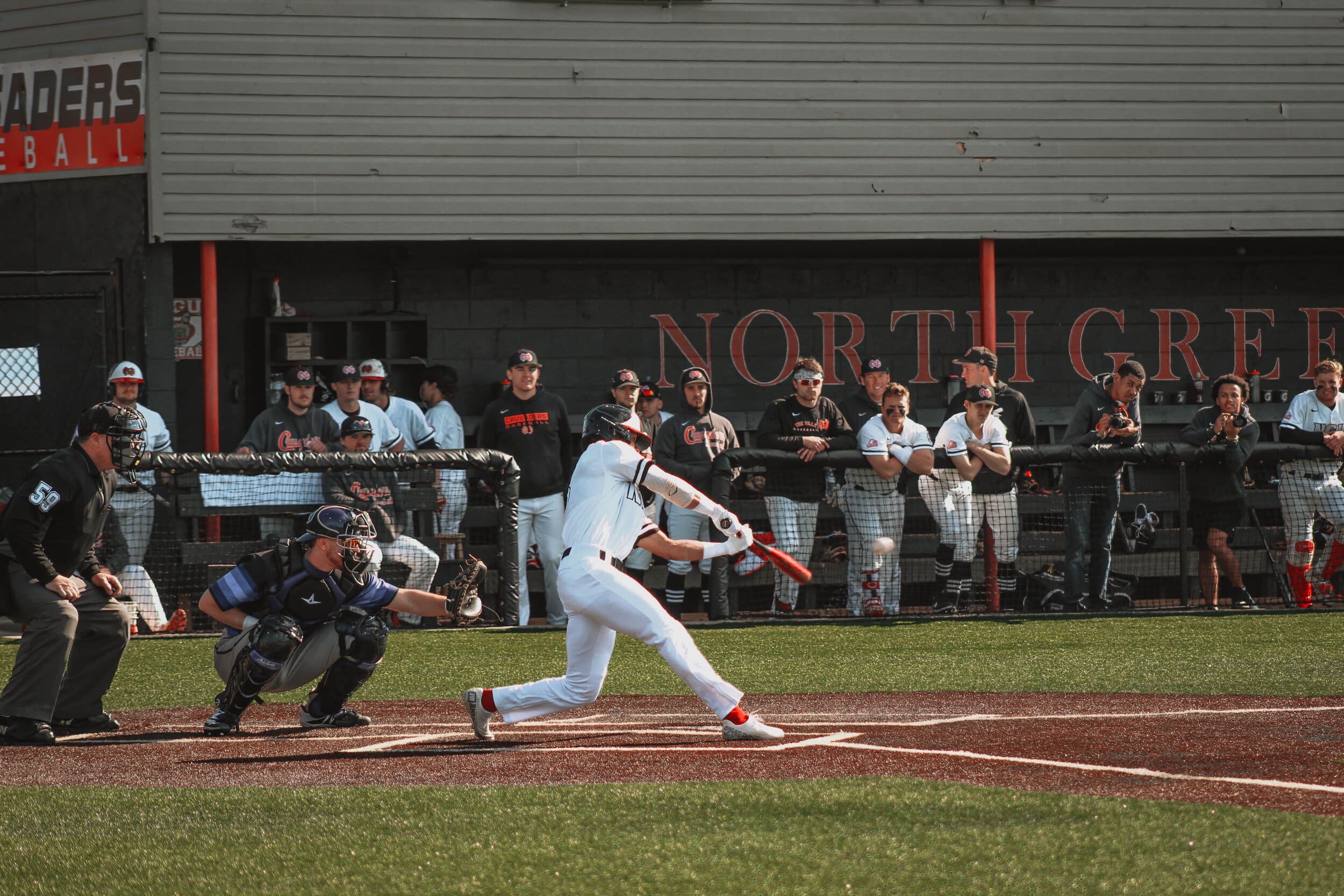 Jeremy Whitehead (8), an NGU junior, swings the bat for a hit.