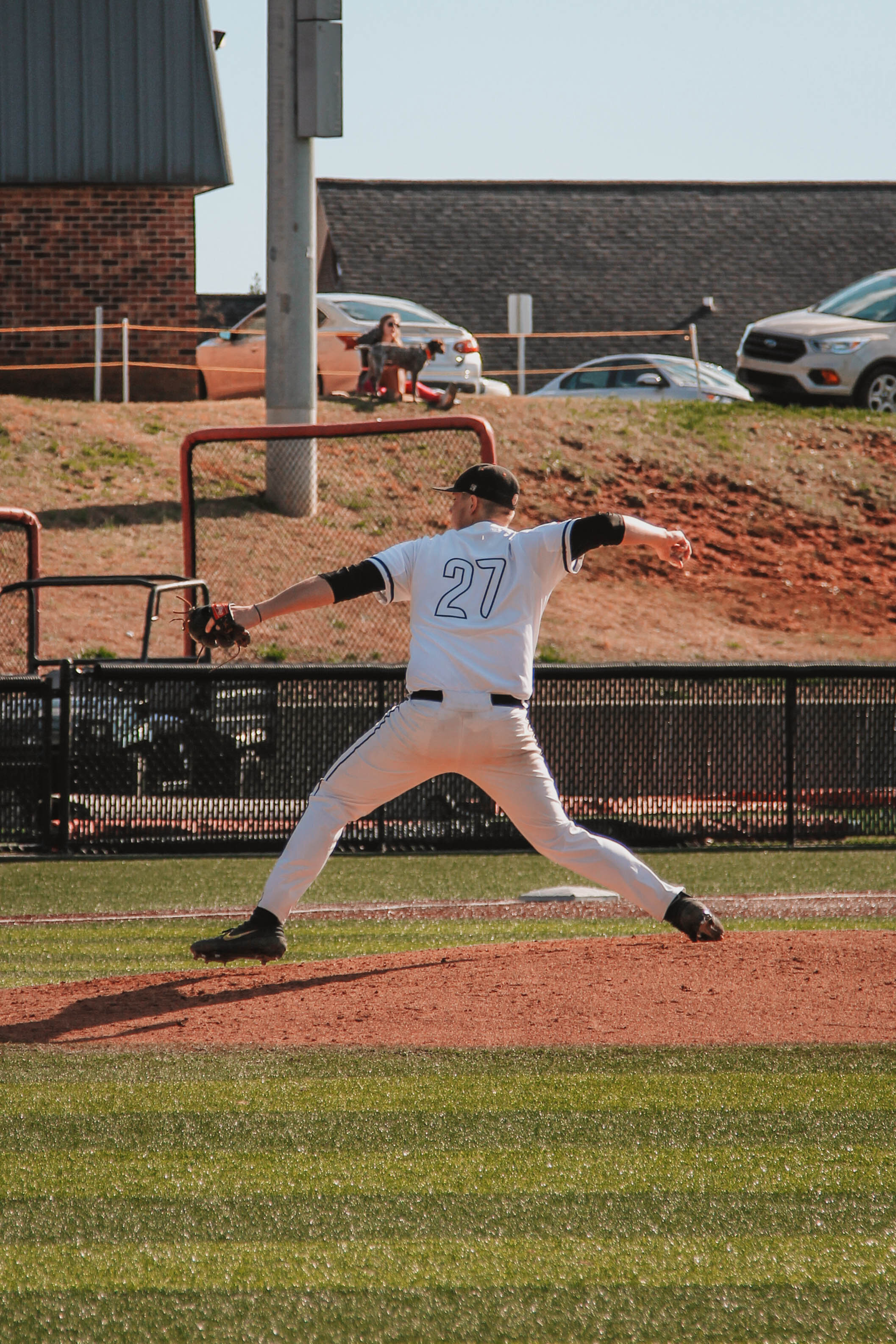 Pitcher Ethan Garner (27), a Crusader senior, winds back to pitch the ball.