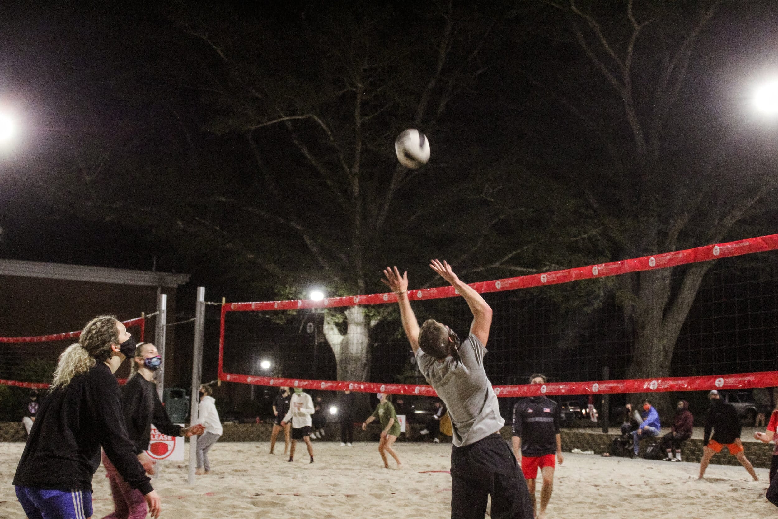 This Intramural sand volleyball team prepares to tip the ball over the net.