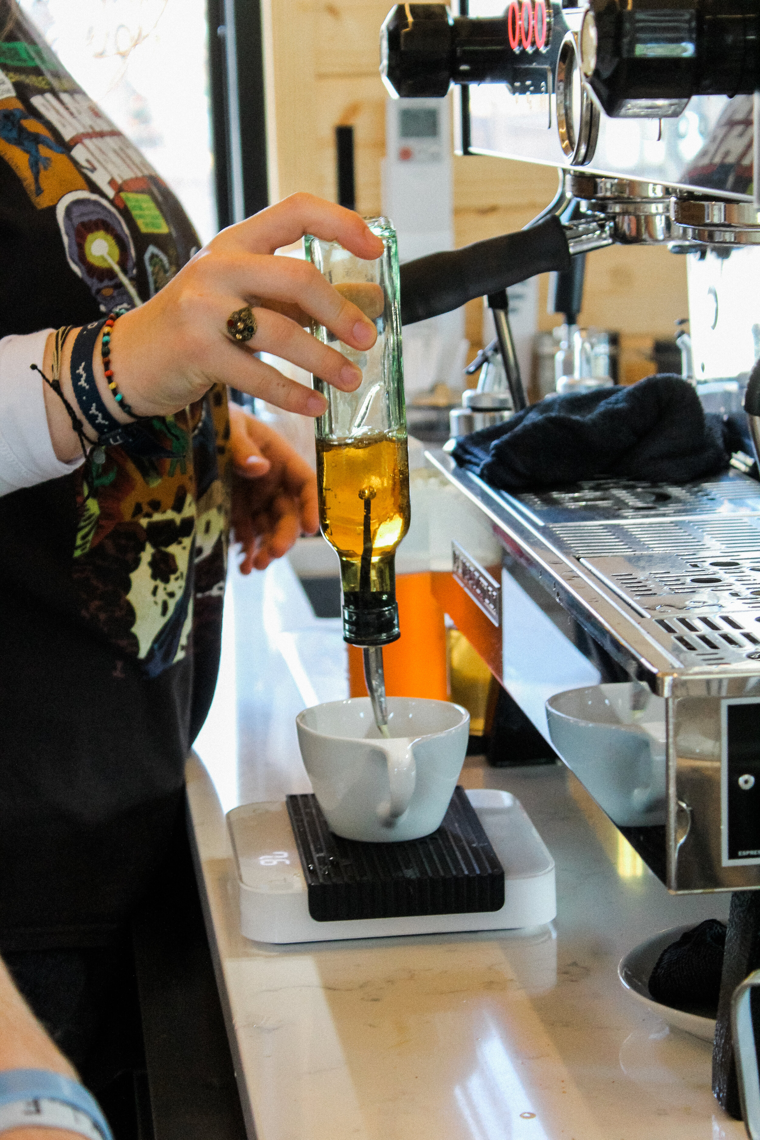 The barista puts flavored syrup, if asked for by a customer, into the mug.