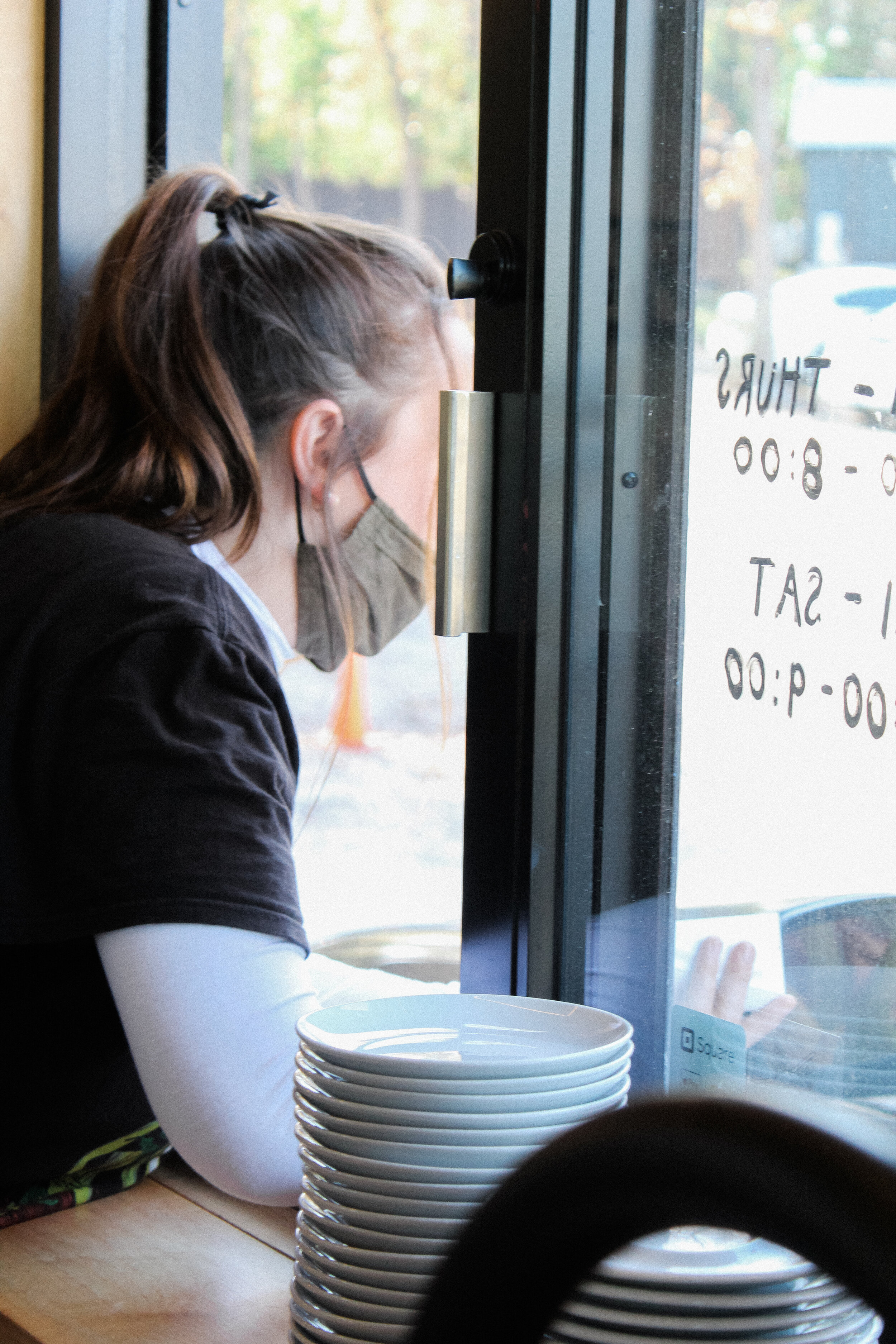 Along with the rush of making drinks for customers indoors, baristas at Scandi Tiny must also take orders in the drive-thru. Here, we see barista Julie Gromer taking a drive thru order.