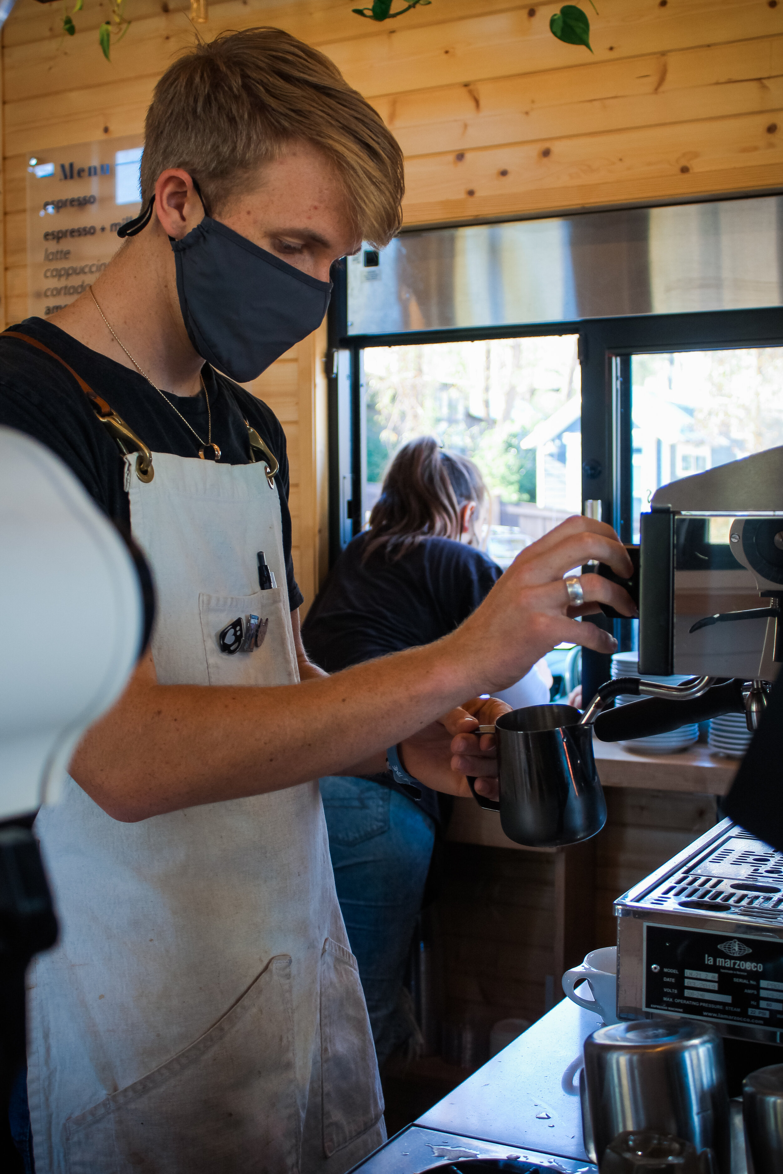 Barista Jacob Ertter finishes up the final stages of making a cappuccino.
