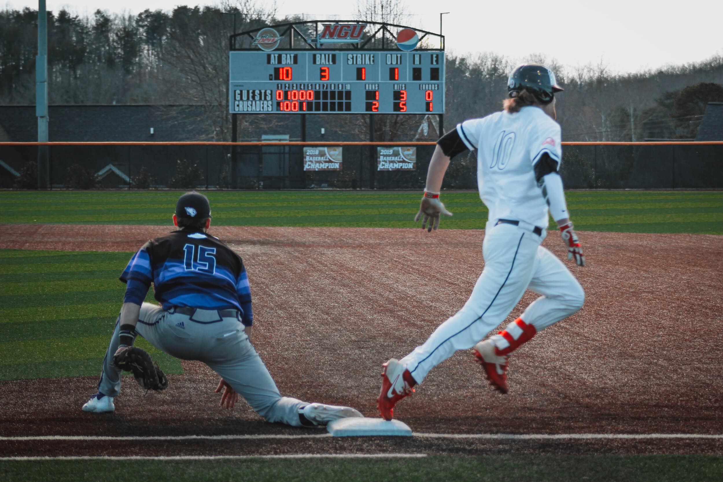 Junior, Michael Neustifter (10), runs through first base as the Panther first base player waits for a pass from his teammate.