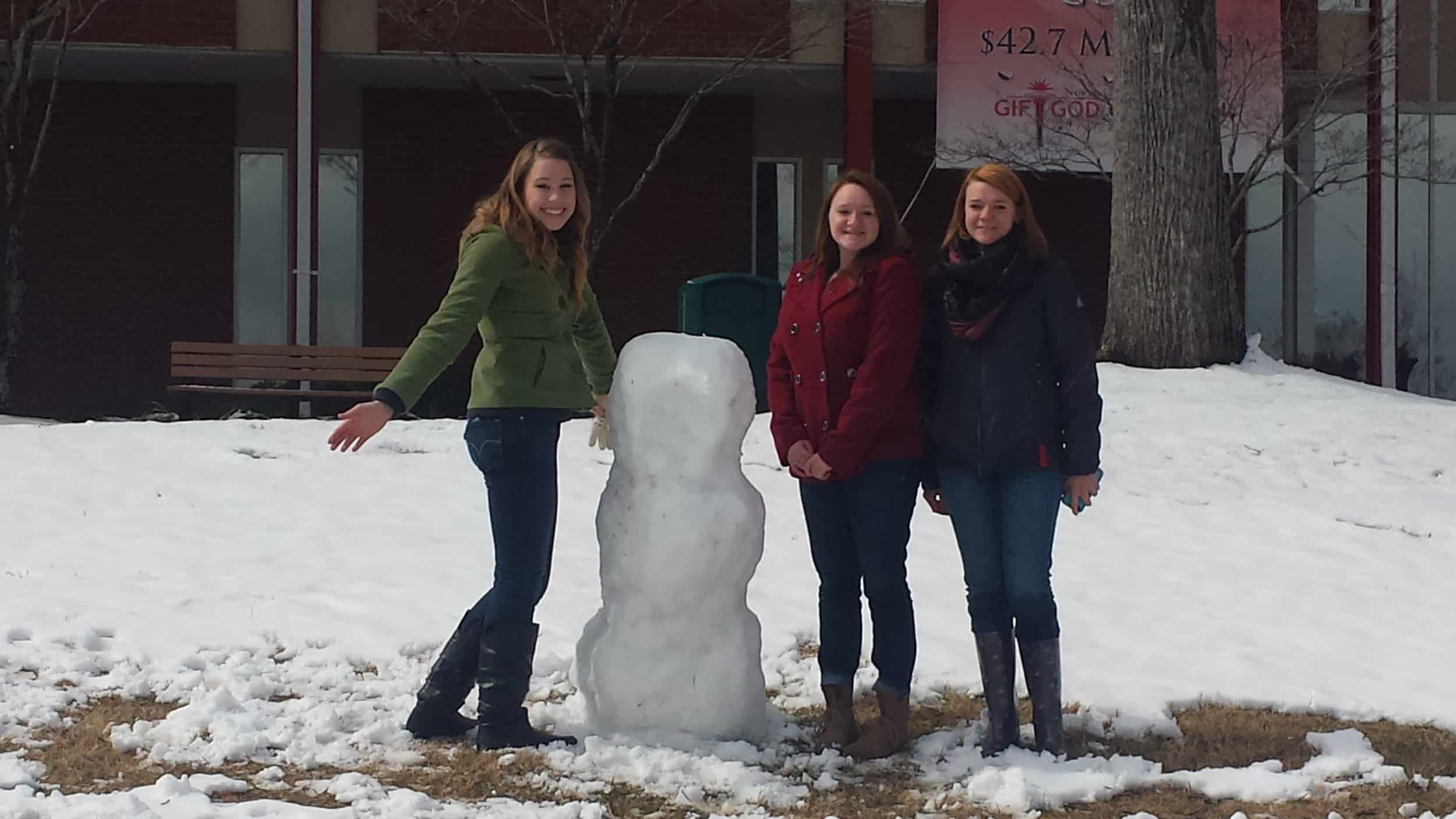 Students Rebekah Kington, Sabrina Cook&nbsp;and Samantha Cook build a snowman Thursday morning.Photo by Megan Conley