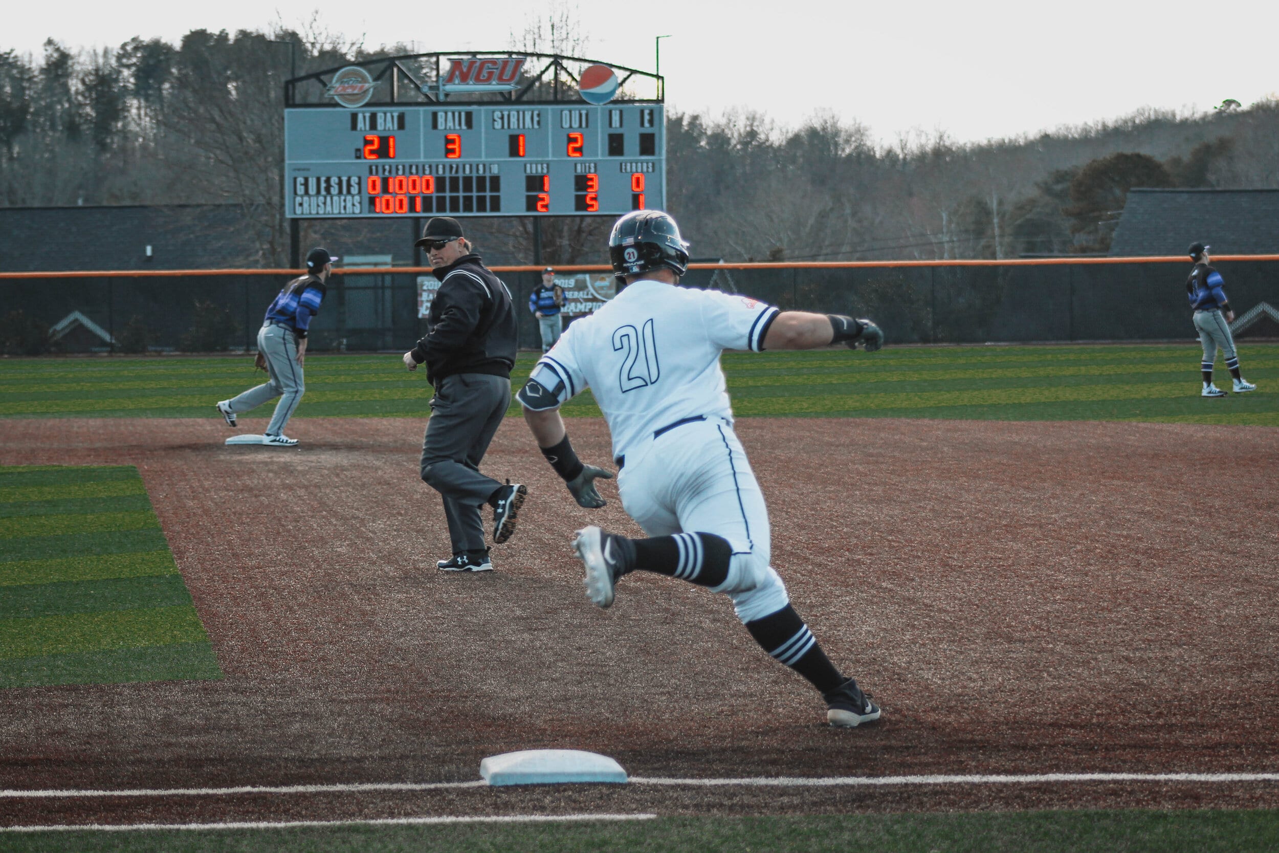 Jordan Holladay (21), first baseman, rounds first base after hitting a double.