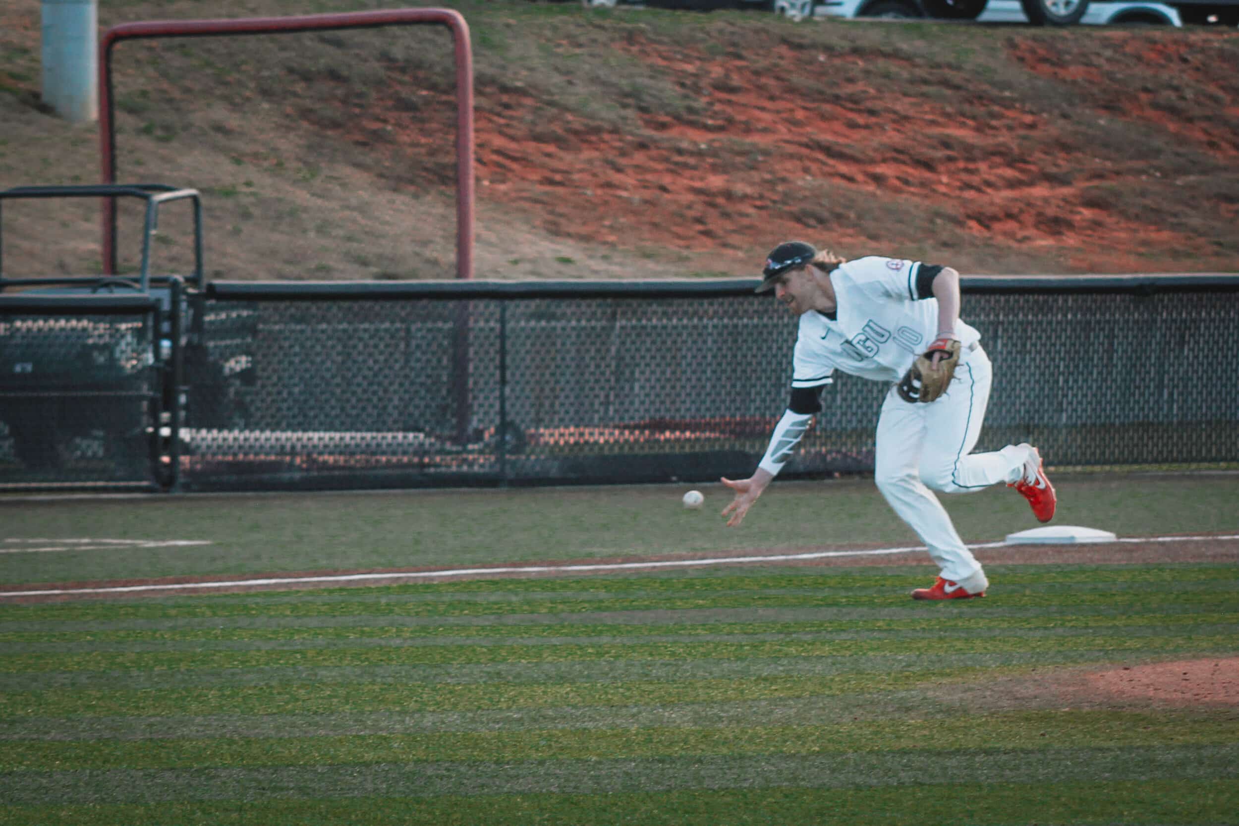 Third baseman Michael Neustifter (10), attempts to catch a ground ball hit down the third base line.