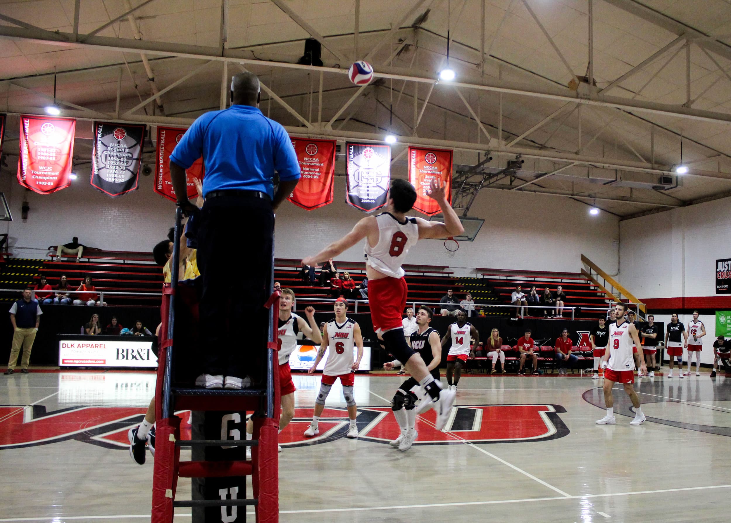 Jackson Gilbert (8) jumps to hit the ball over the net past the opposing teams players