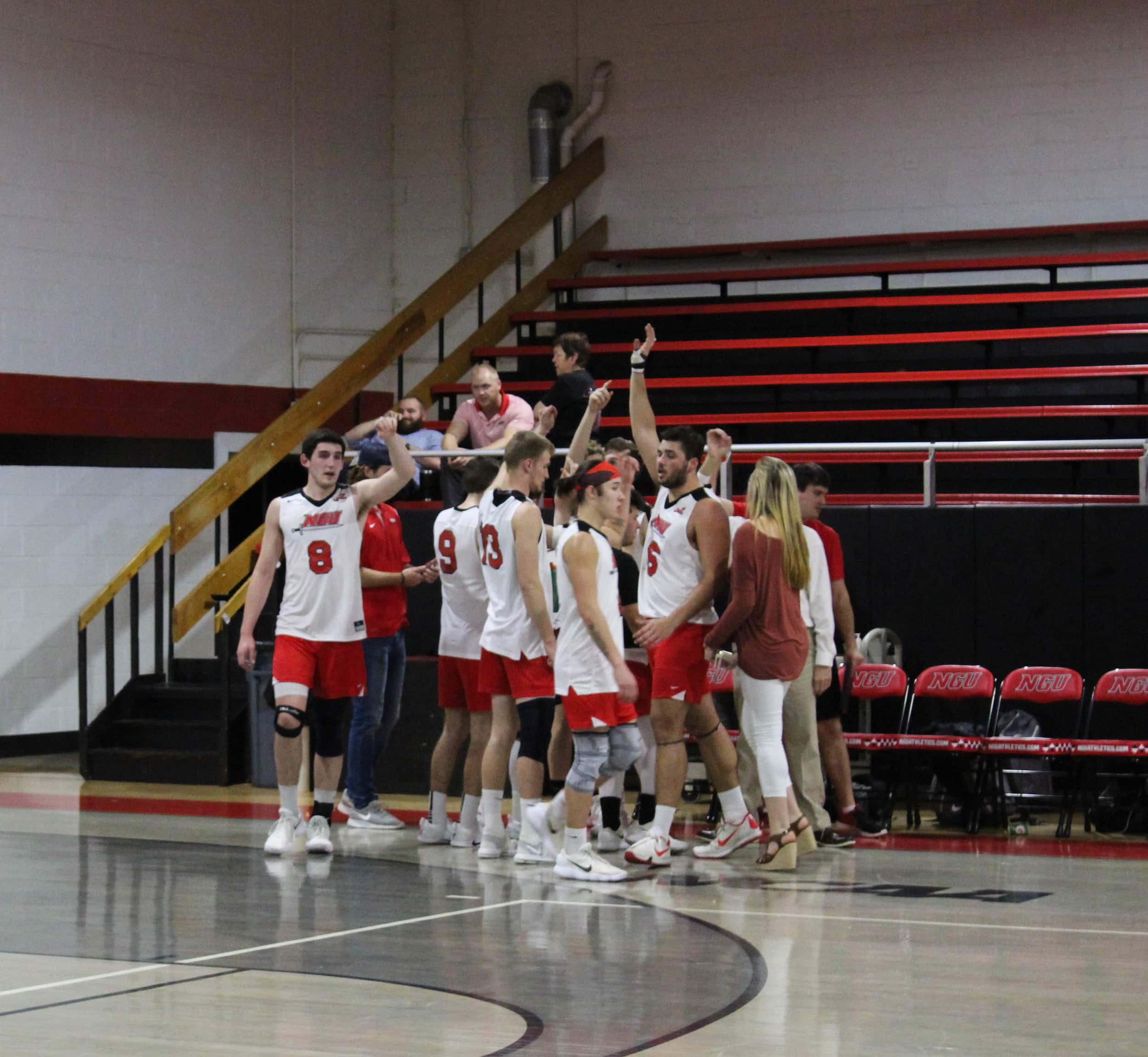 The NGU Mens Volleyball team huddle together during a timeout.