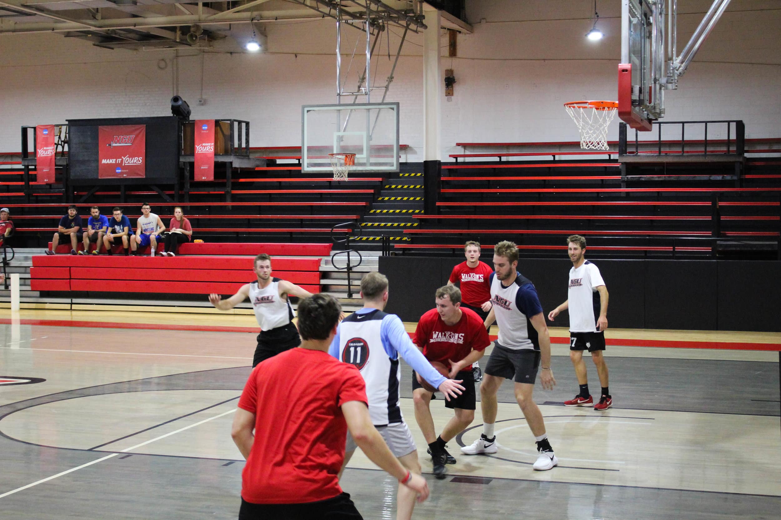 Aaron Gravely attempts to dribble away from the two defenders guarding him.