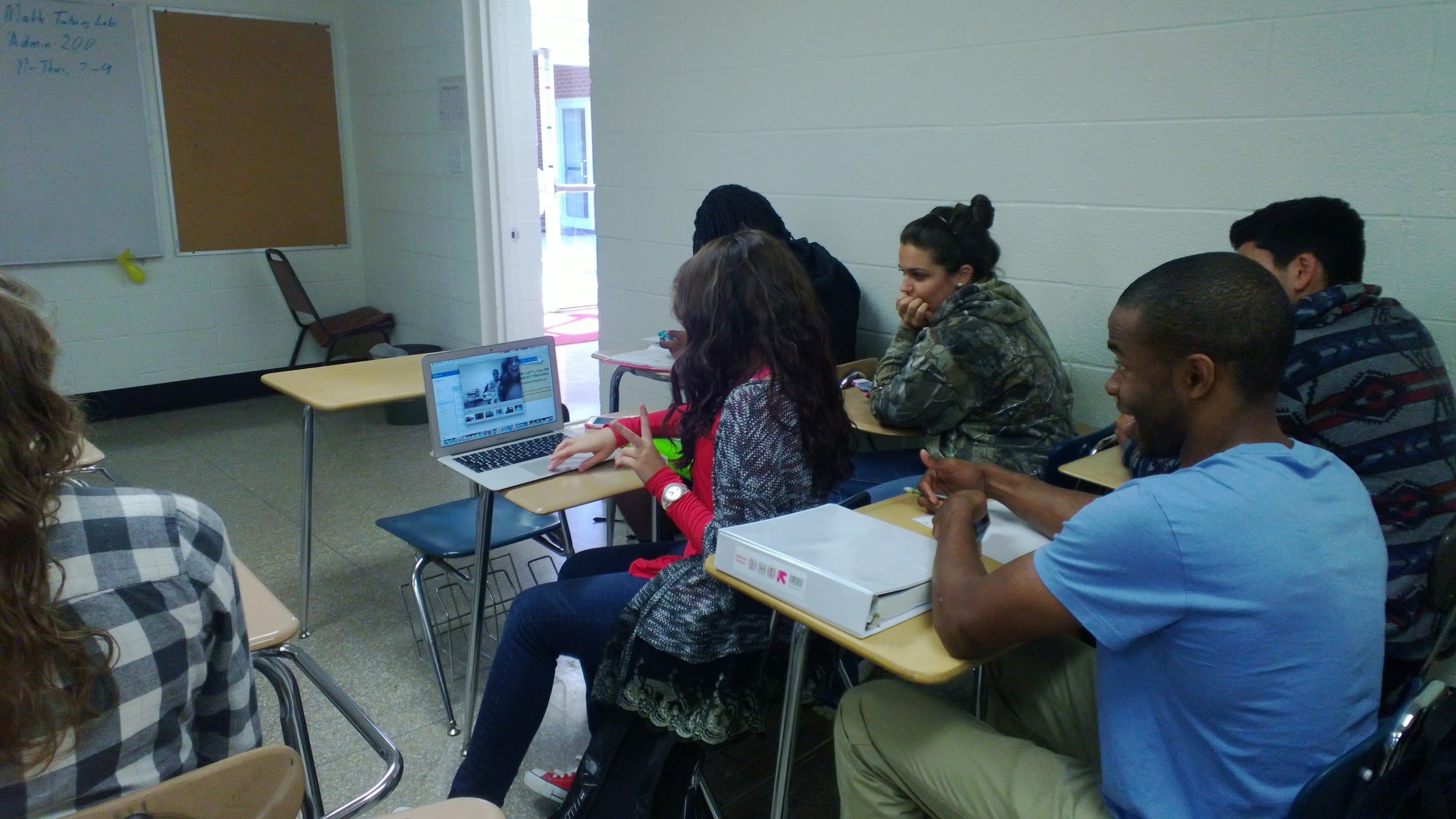 Freshman Danielle Berry (front seat, middle row) &nbsp;takes pictures on her computer with freshman&nbsp;Rodney Walton (back seat, middle row) and distracts freshman Sarah Sealey (second seat, right row).