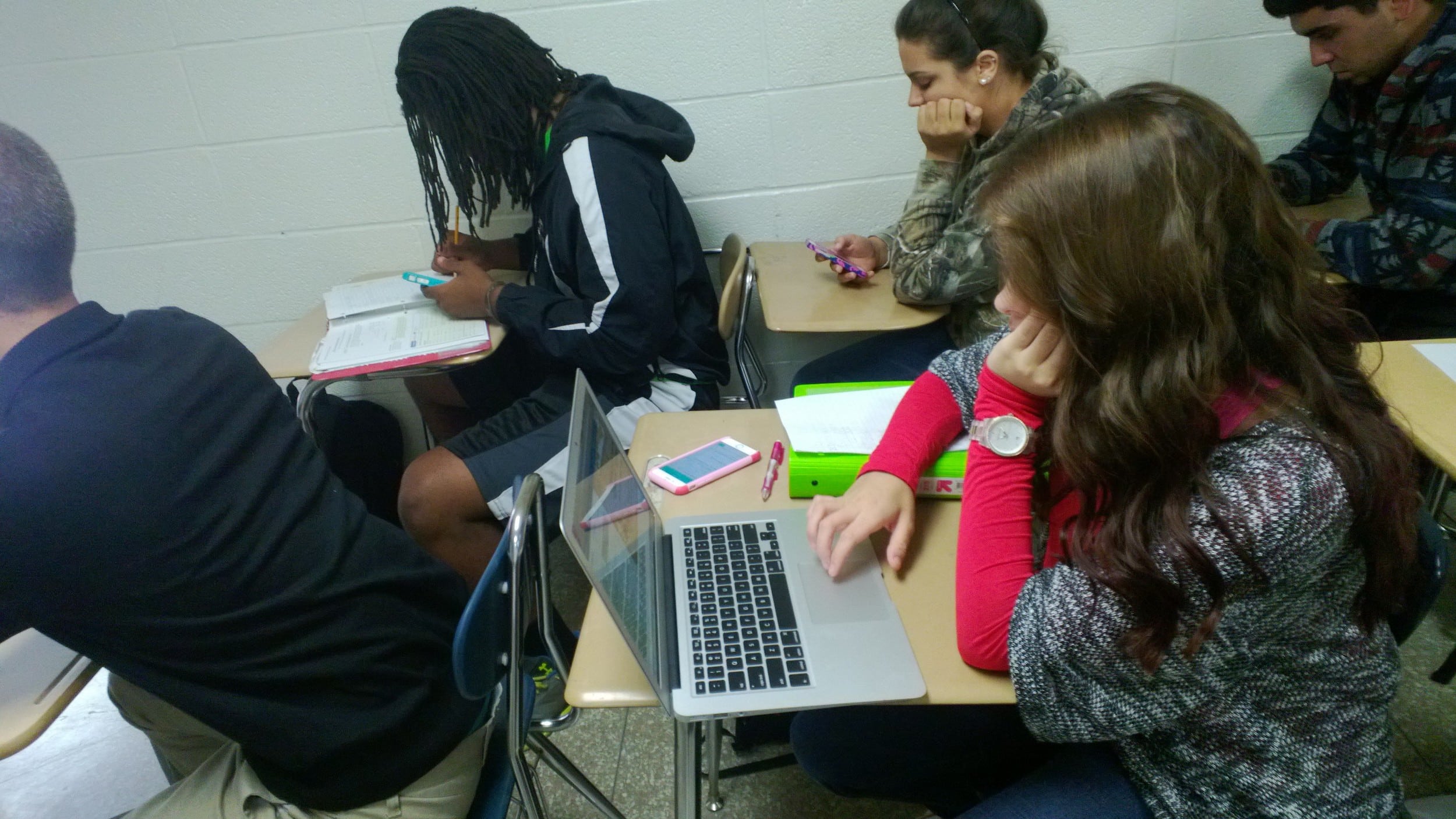 Freshman Danielle Berry (bottom right) sits on her computer in class.